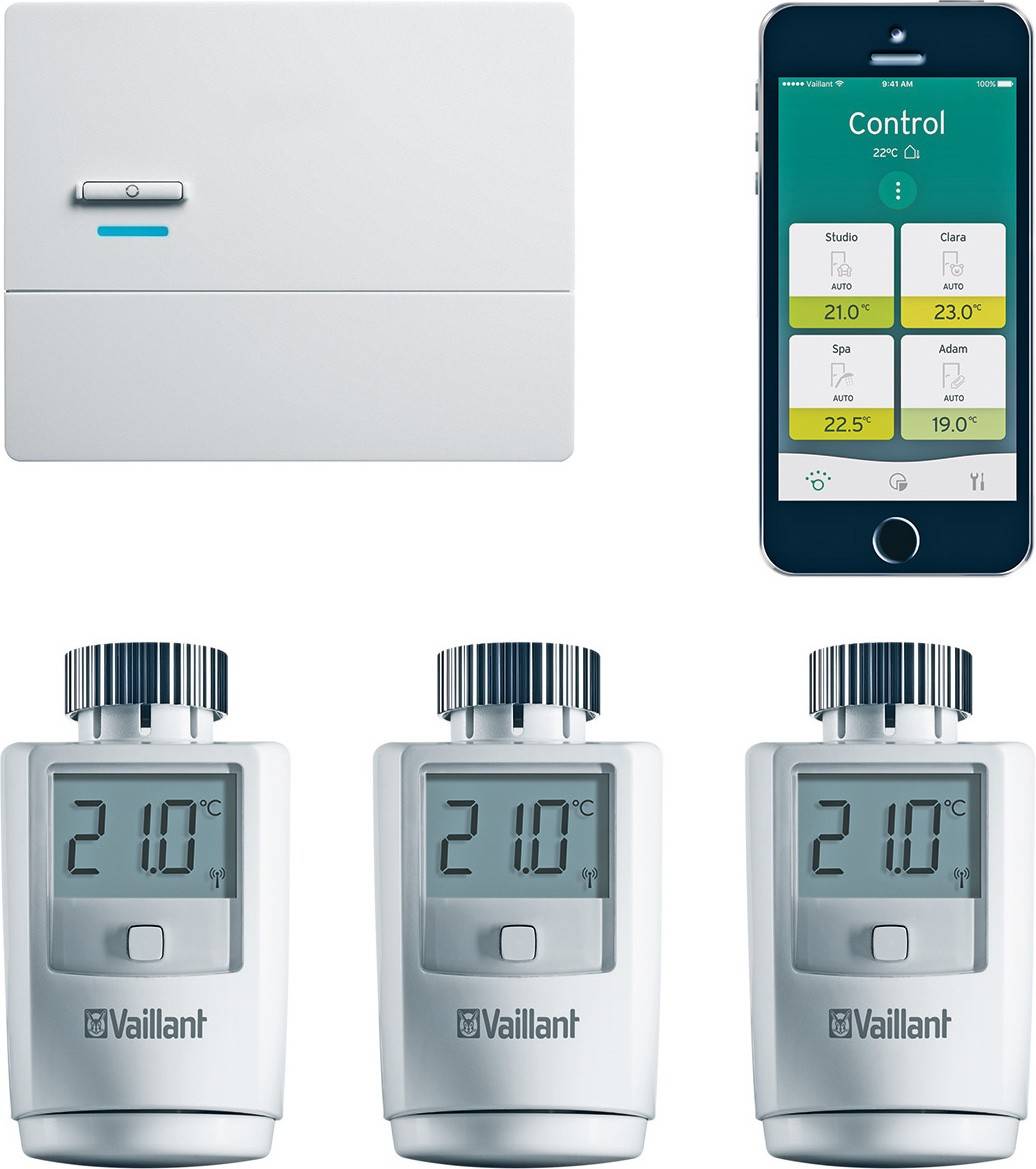Ein Set aus einer Steuereinheit, einem Smartphone mit Temperatur-App und drei Heizkörperthermostaten von Vaillant, die 21°C anzeigen.