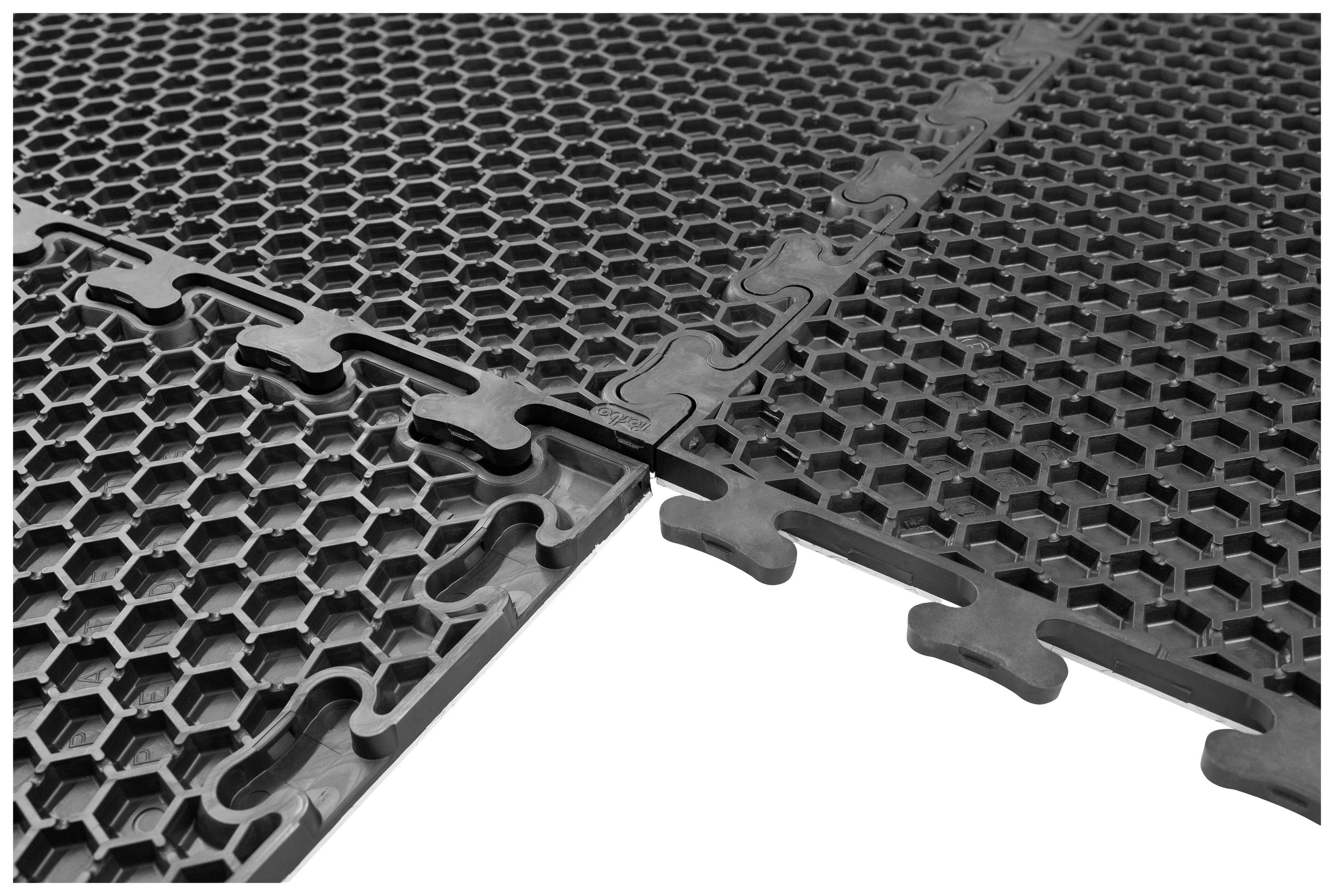 Schwarze Steckmatten mit sechseckigem Muster, passend verzahnt. Geeignet für Bodenbeläge in Sport- oder Spielbereichen.