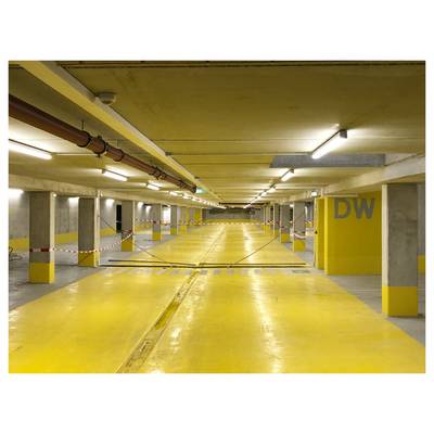 Flur in einem Gebäude mit mehreren geschlossenen Türen, die nummeriert sind, wobei die Tür mit der Nummer '522' im Fokus steht. An der Decke sind sichtbare Versorgungsleitungen und Beleuchtung zu sehen.