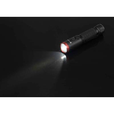 Eine schwarze Taschenlampe liegt auf einer dunklen Oberfläche und leuchtet mit einem weißen Lichtstrahl nach links.