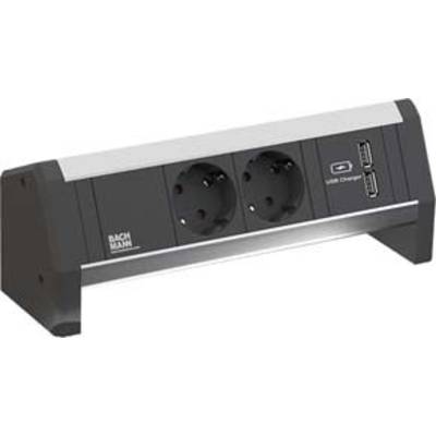 Eine schwarze Steckdosenleiste mit zwei Steckdosen und zwei USB-Ladeanschlüssen, die auf einem Tisch oder einer Arbeitsfläche steht.