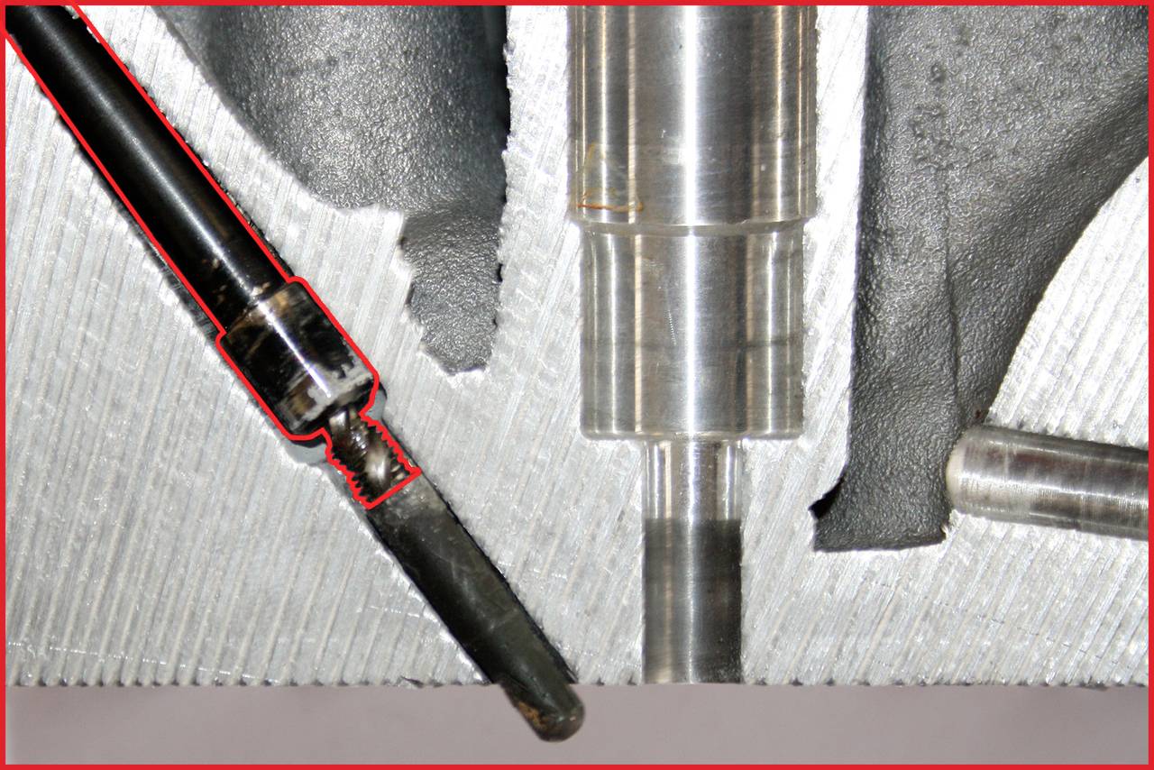 'Nahaufnahme eines mechanischen Teils mit rauer Oberfläche. Links ist ein abgenutztes Metallwerkzeug zu erkennen. Aufnahme zeigt Schnittstelle und Details.'