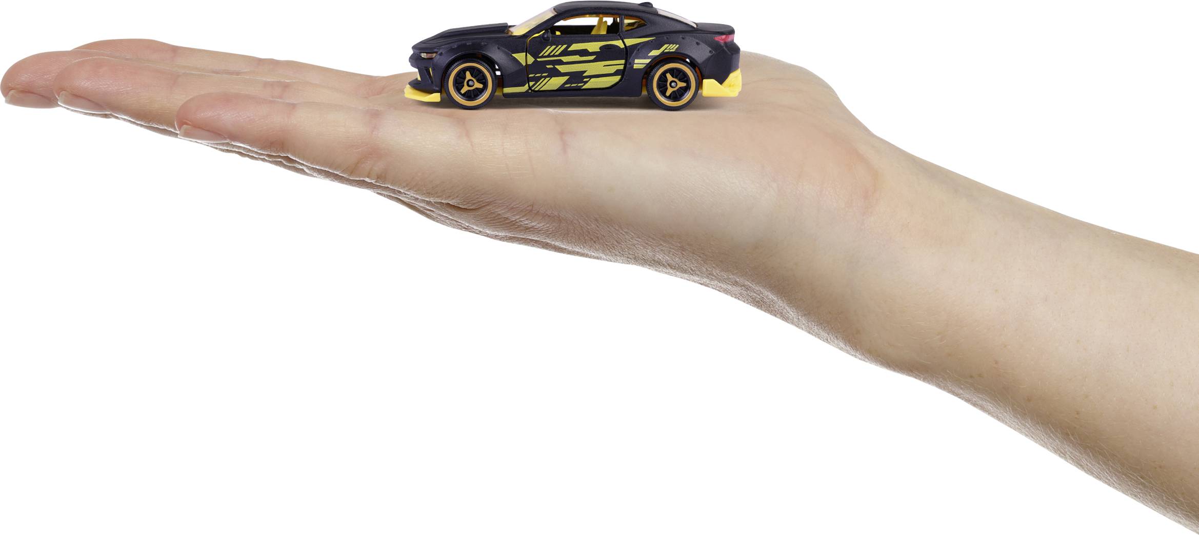 Eine offene Handfläche hält ein kleines, schwarzes Spielzeugauto mit gelben Details.