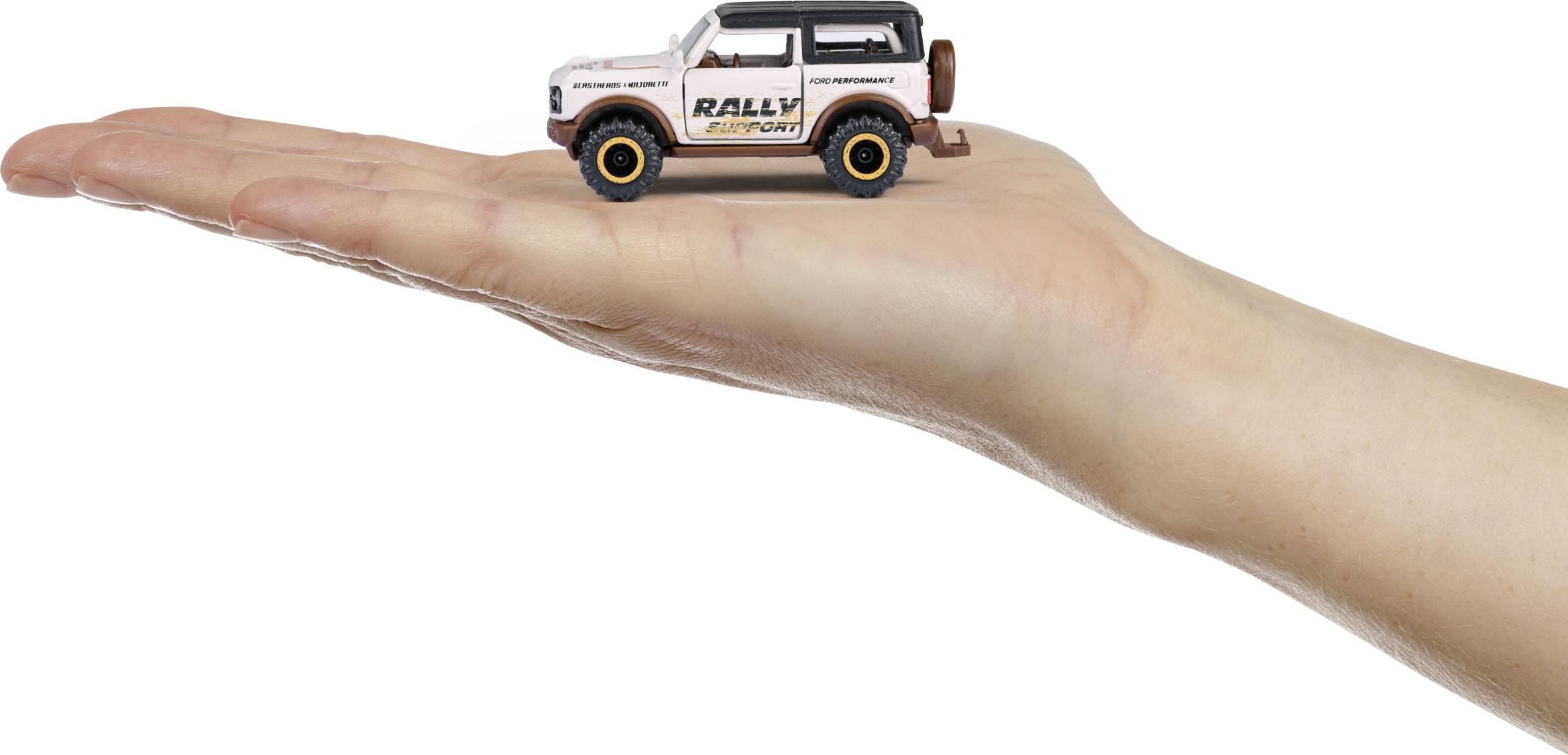 Eine Hand hält ein kleines Modellauto, das für Rallyes gestaltet ist. Das Auto ist weiß mit der Aufschrift 'Rally Support'.