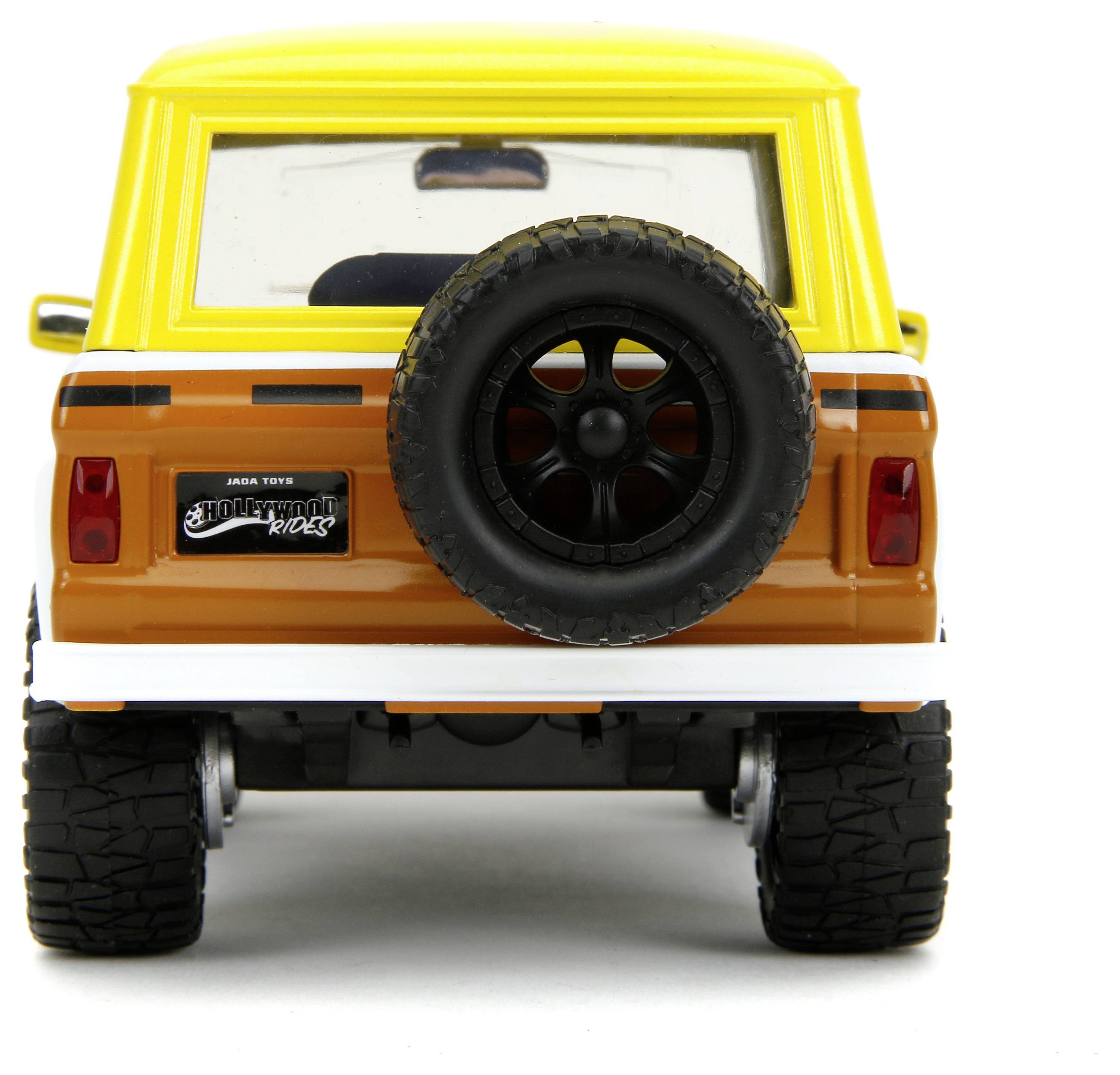 Ein gelb-orangefarbenes Spielzeugauto von hinten mit Reserverad an der Rückseite. Quadratische Form und Spielzeugräder.
