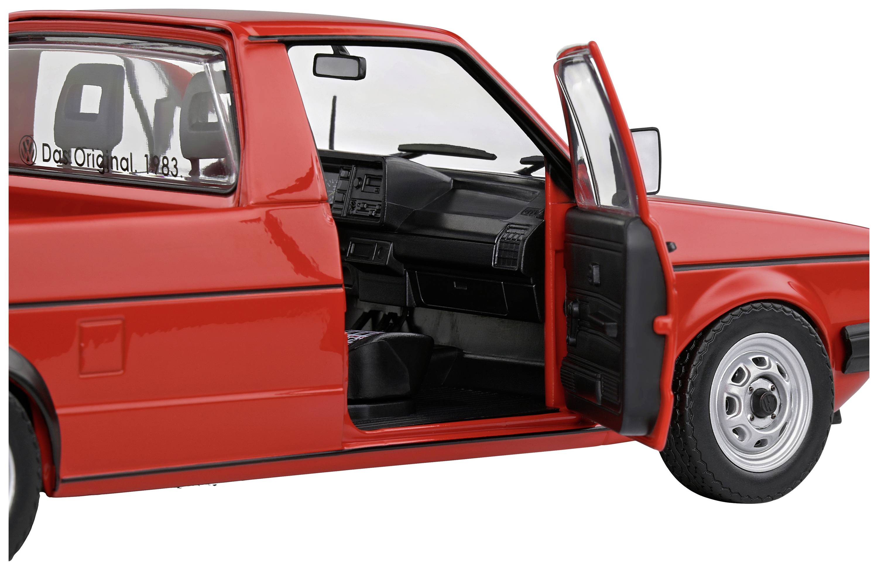 Ein rotes Auto mit geöffneter Fahrertür, zeigt den Innenraum mit Lenkrad und Sitzen. Modell 'Golf 1983' auf dem Armaturenbrett.