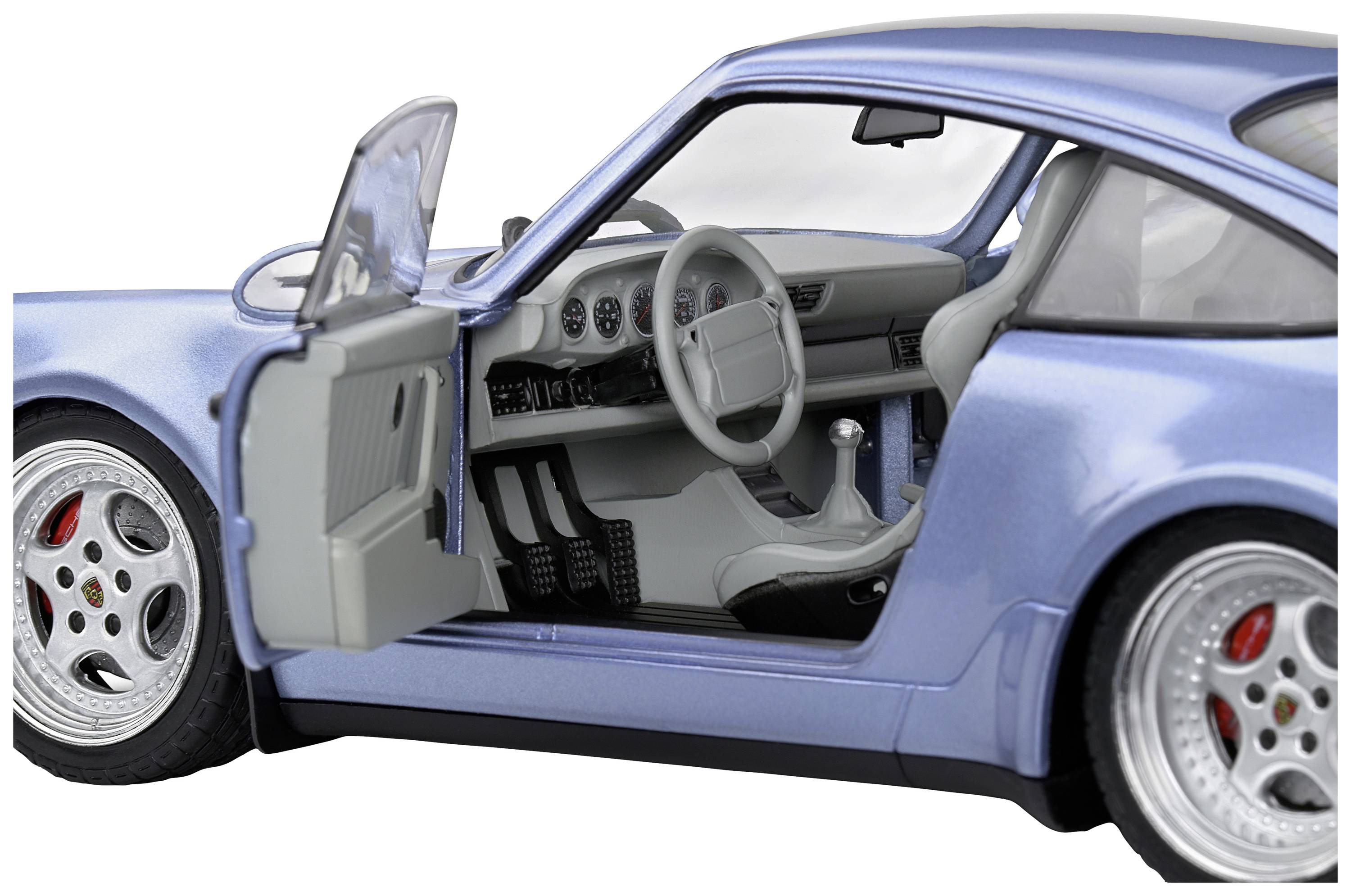 Ein blauer Sportwagen mit geöffneter Fahrertür zeigt das detaillierte Interieur, einschließlich Lenkrad und Armaturenbrett.