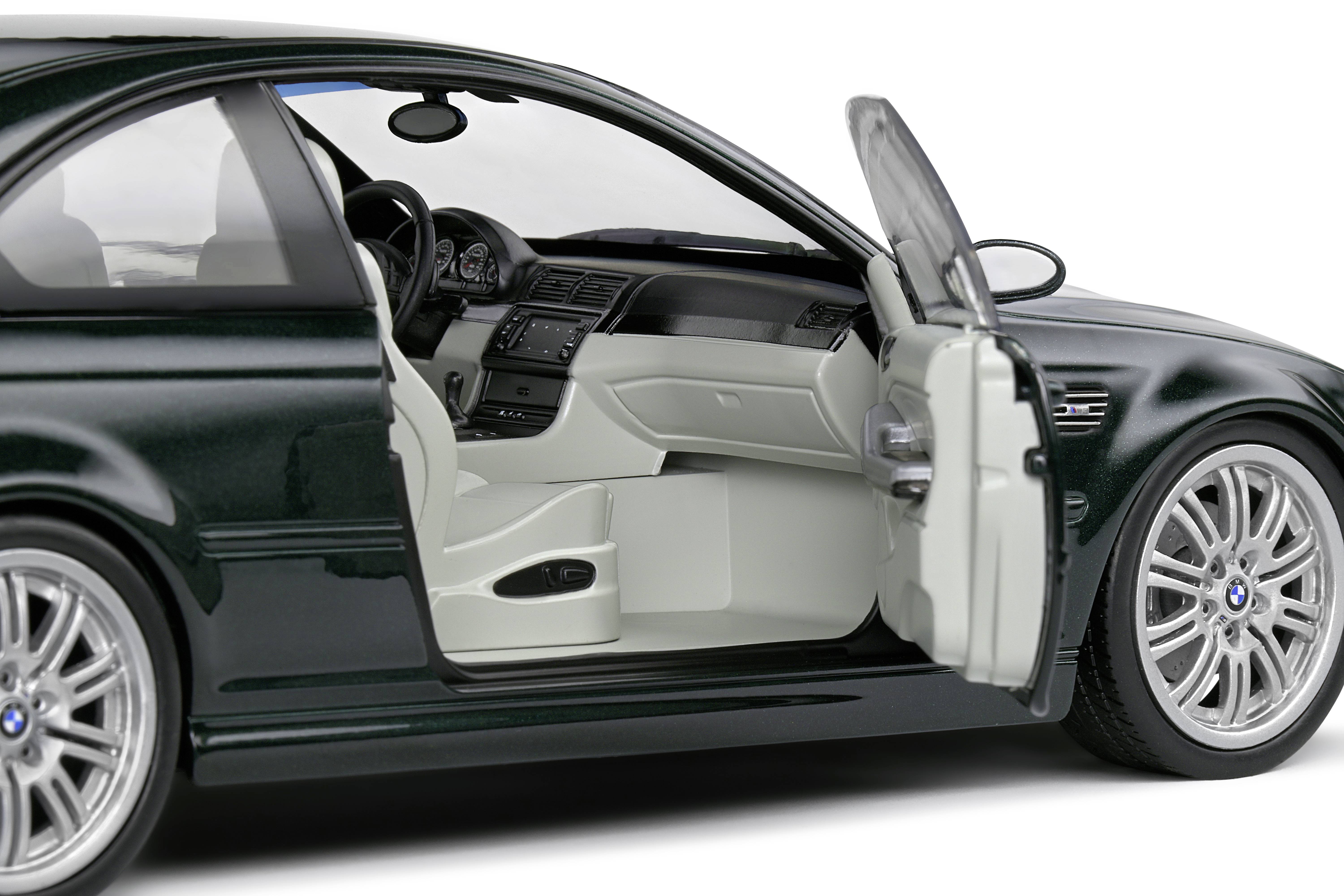 Ein schwarzes Auto mit geöffneter Fahrertür zeigt das Interieur. Sichtbar sind der Lenkradbereich, der Armaturenbrett und die Sitze.