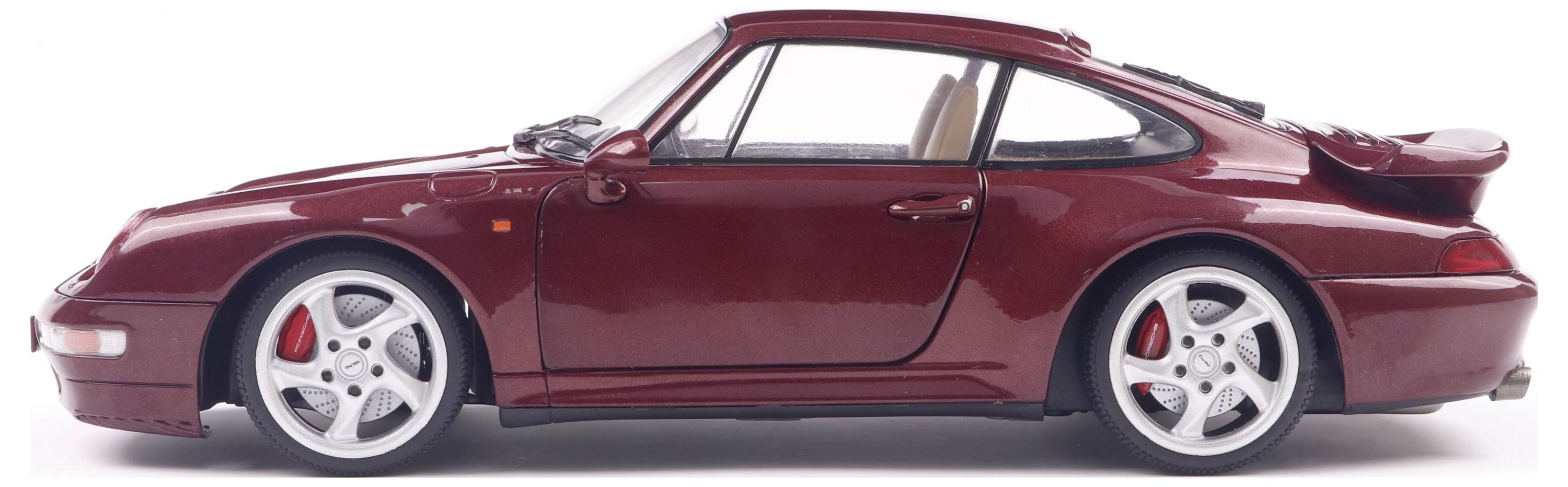 Ein rotes Auto, seitlich fotografiert, mit sportlichem Design und markanten Felgen.
