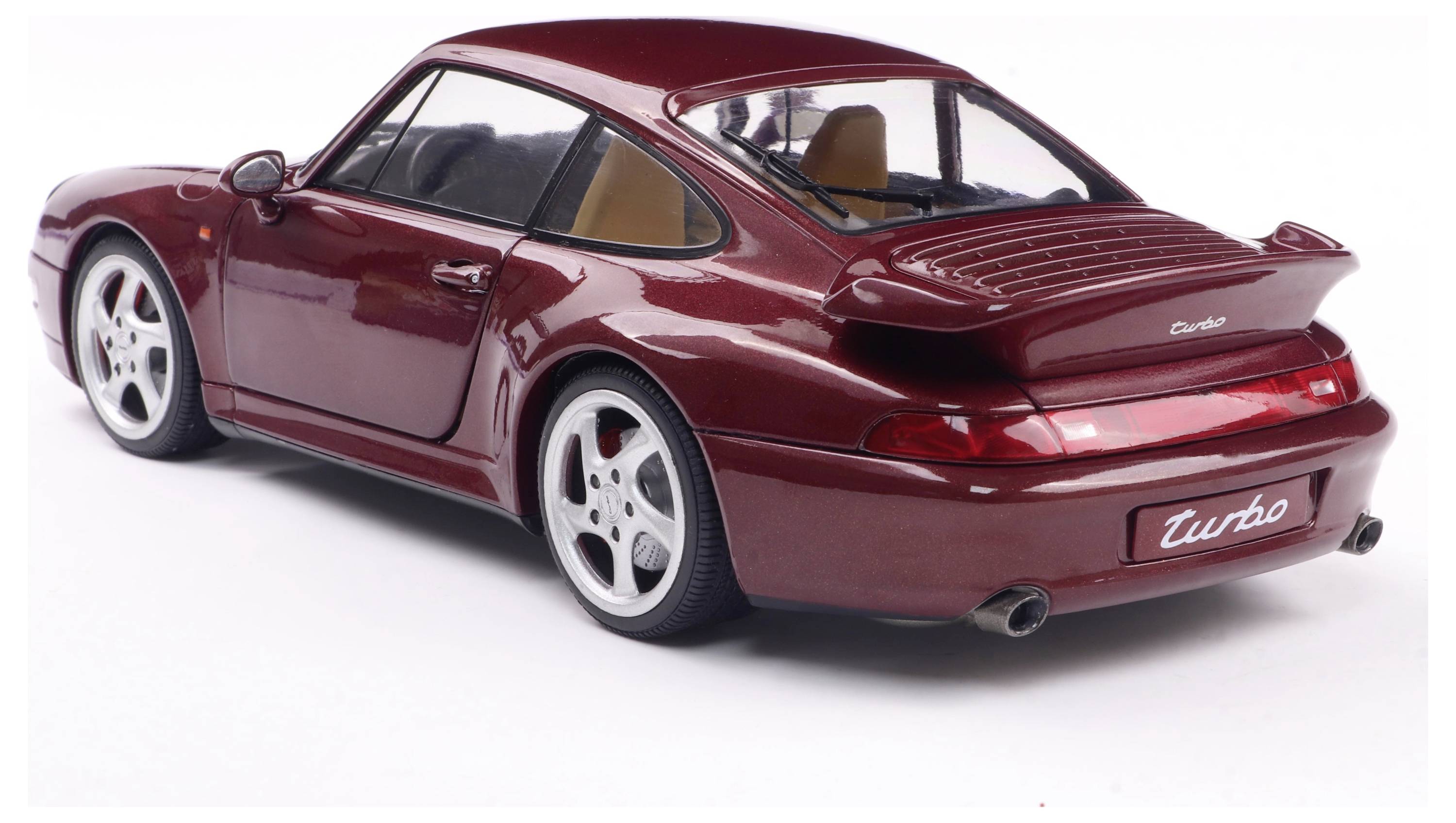 Rotes Auto, Modell Porsche 911 Turbo, Rückansicht. Der Wagen steht auf einem weißen Hintergrund und hat ein elegantes, sportliches Design.