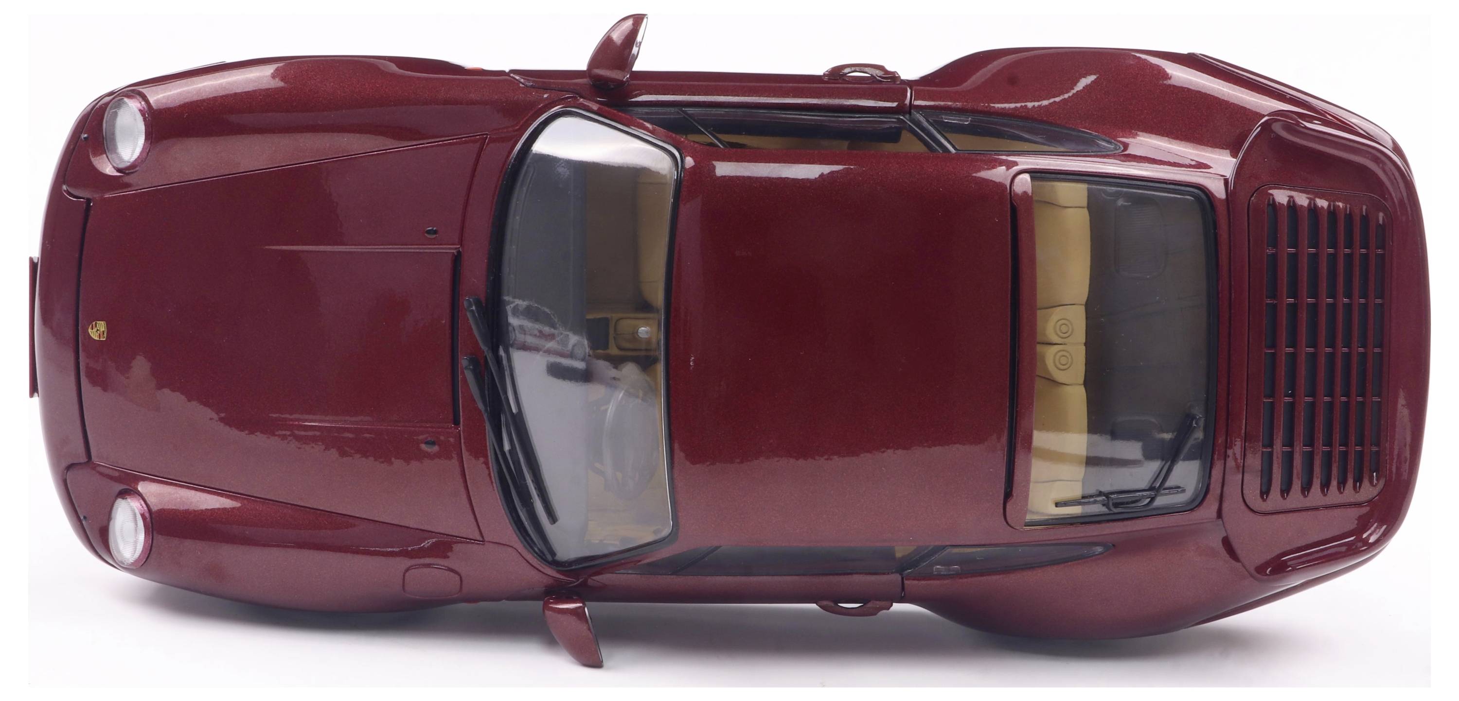 Ein rotes Spielzeugmodell eines klassischen Sportwagens, von oben gesehen. Die Türen und das Dach sind sichtbar.