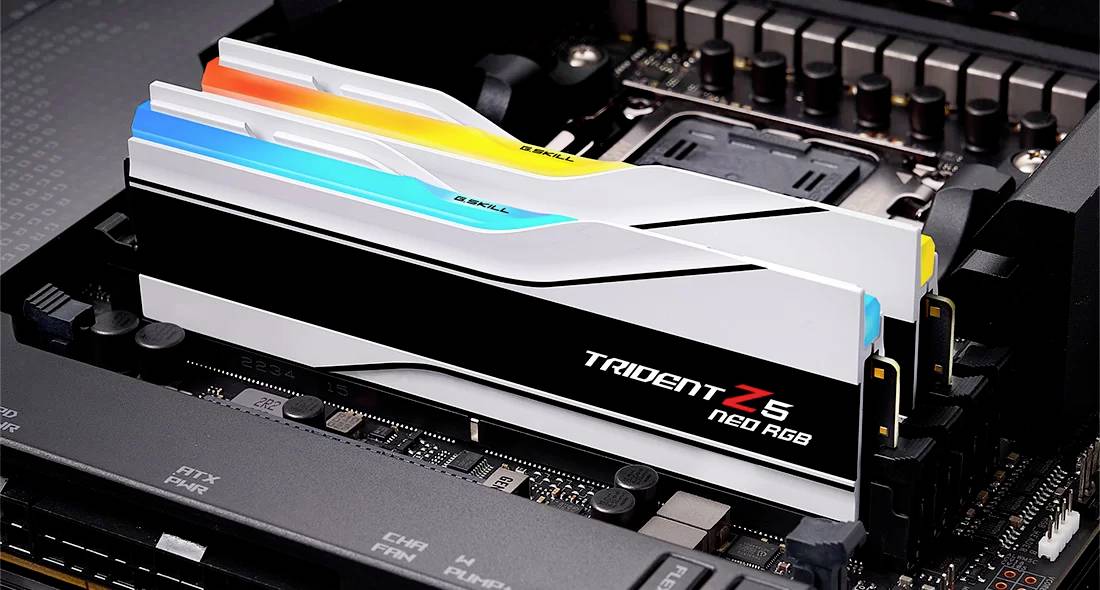 Nahaufnahme von zwei installierten, mehrfarbigen RGB-RAM-Sticks in einem Computer-Motherboard, mit der Aufschrift 'Trident Z5'.