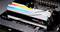 Nahaufnahme von zwei installierten, mehrfarbigen RGB-RAM-Sticks in einem Computer-Motherboard, mit der Aufschrift 'Trident Z5'.
