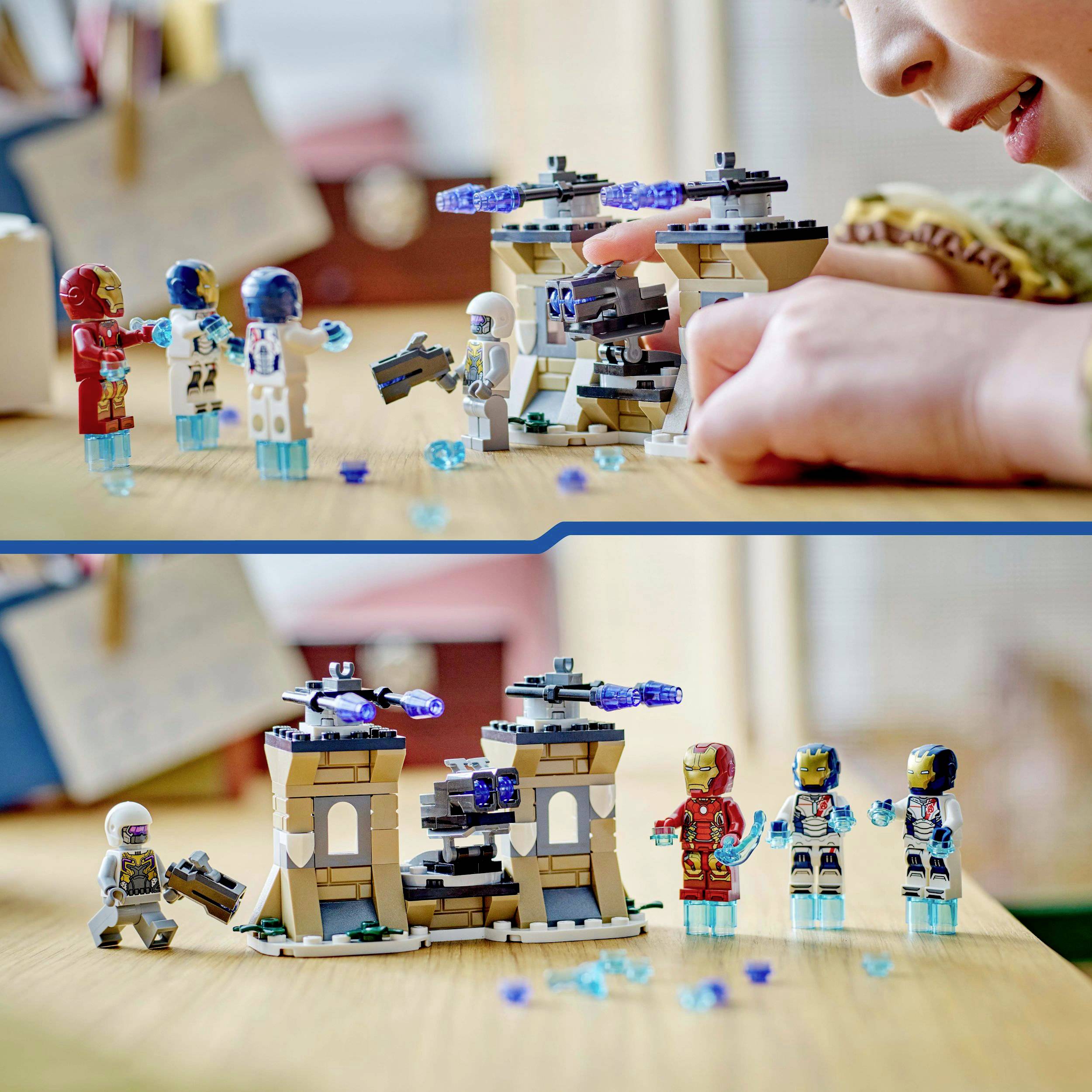 Kinder spielen mit einem Set aus kleinen Roboterfiguren und Bausteinen auf einem Tisch. Eine Figur wird von einer Hand gehalten.