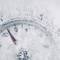 Ein Thermometer zeigt -20 Grad Celsius an, teilweise von Schnee bedeckt, was auf extrem kalte Wetterbedingungen hinweist.