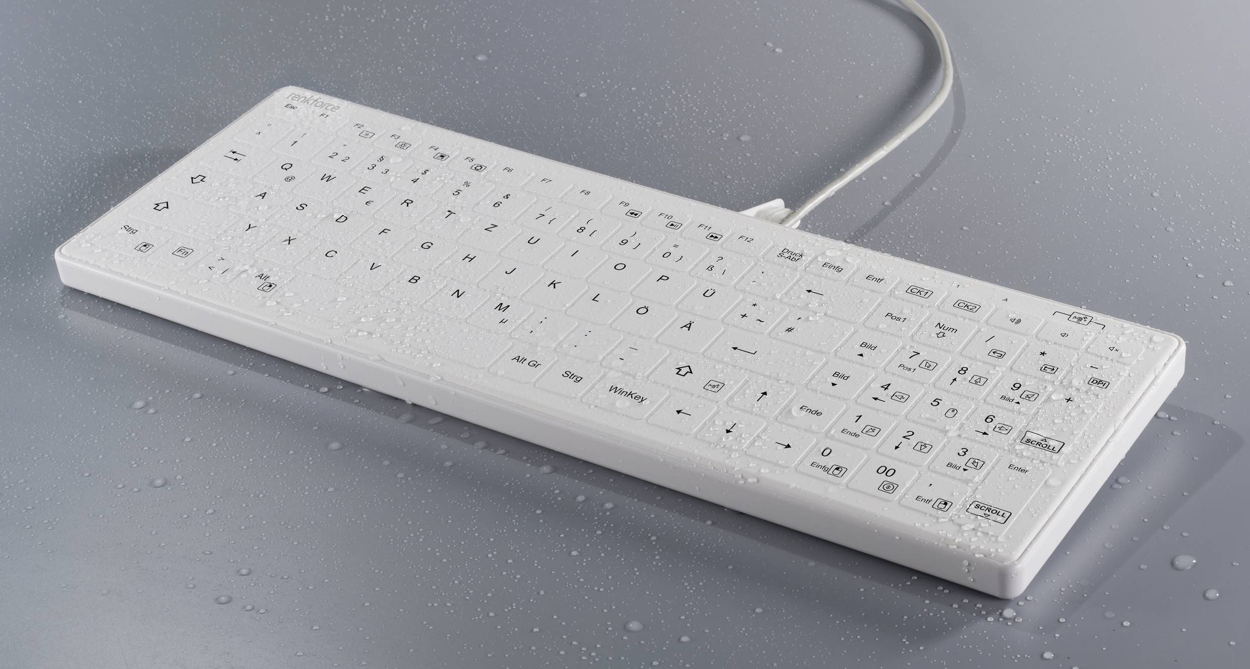 Eine weiße Tastatur mit Wassertropfen darauf, zeigt wasserresistentes Design. Tastatur hat beschriftete Tasten und ist schnurgebunden.