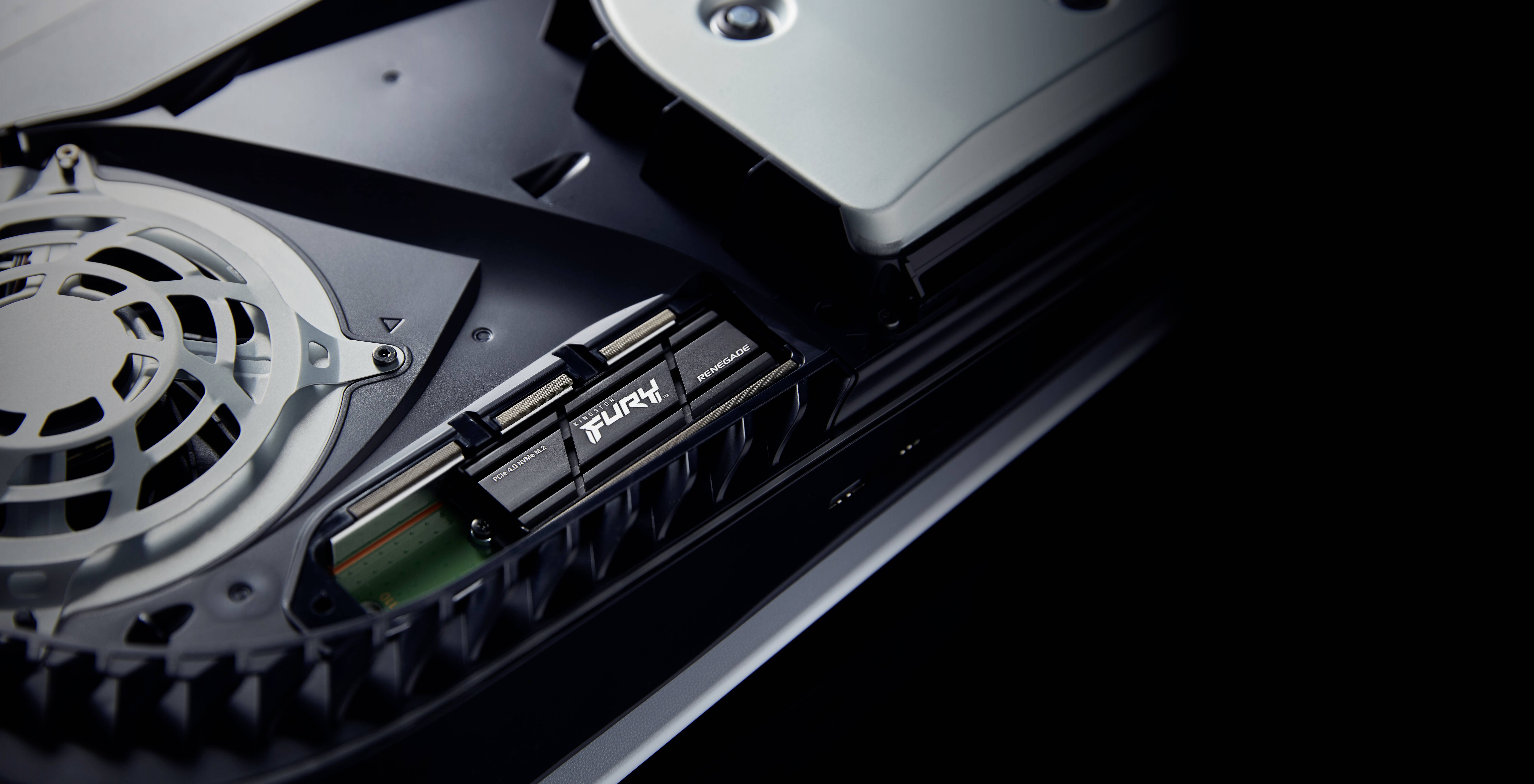 SSD-Einbau in einer Konsole, zeigt eine 'FURY'-SSD im M.2-Steckplatz. Lüfter und Gehäuseteile sind ebenfalls sichtbar.
