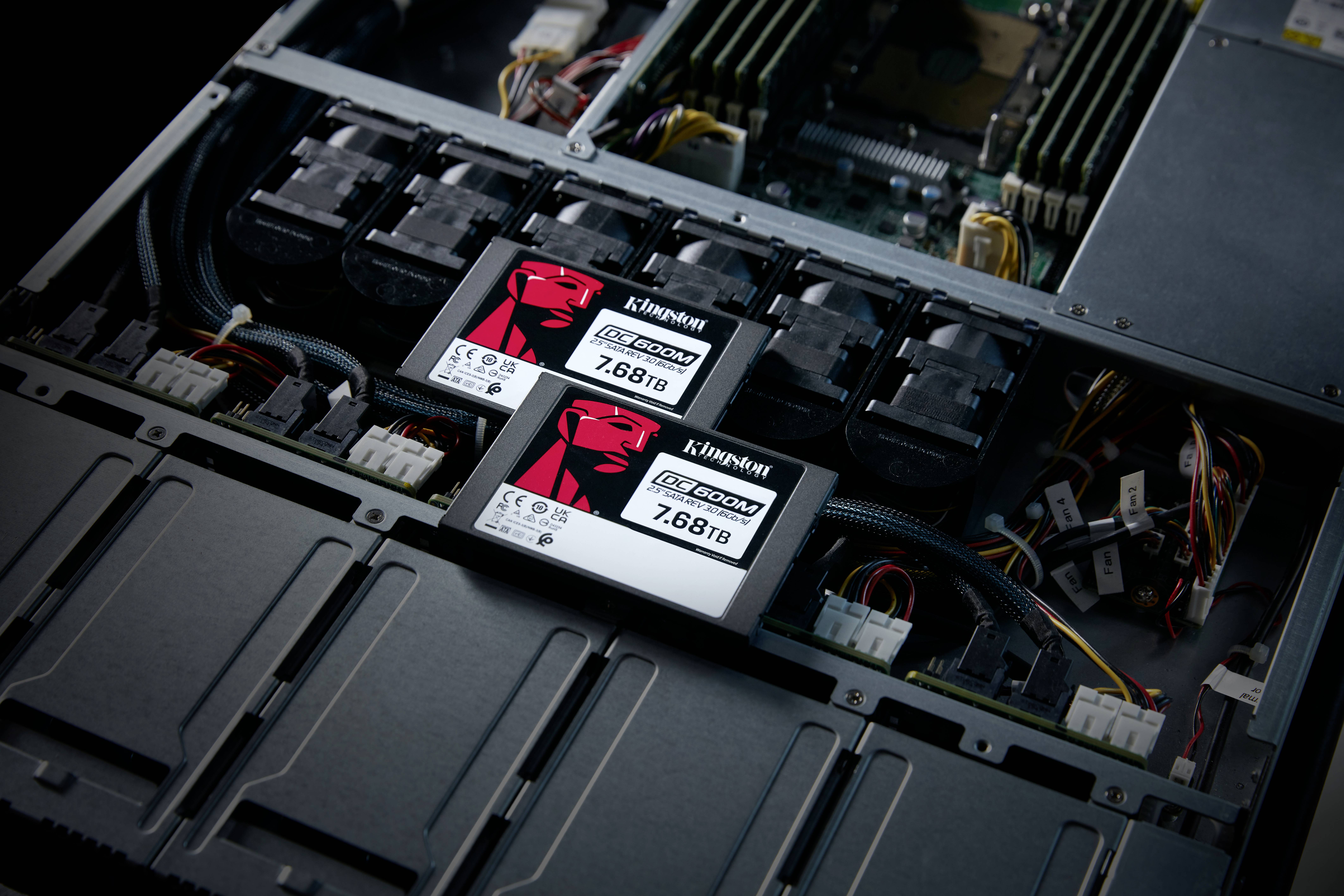 Ein Servergehäuse mit zwei Kingston SSDs, 'DC600M 7.68TB', eingebaut, umgeben von elektrischen Komponenten und Kabeln.