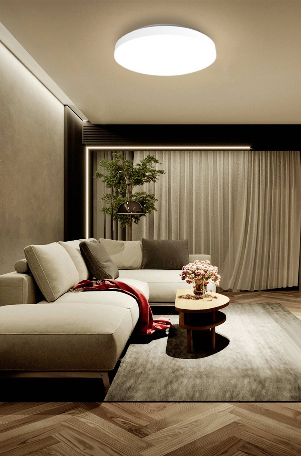 Ein stilvoll eingerichtetes Wohnzimmer mit einer großen, beigen Eckcouch, einem runden Holztisch und einem Teppich auf Holzboden.