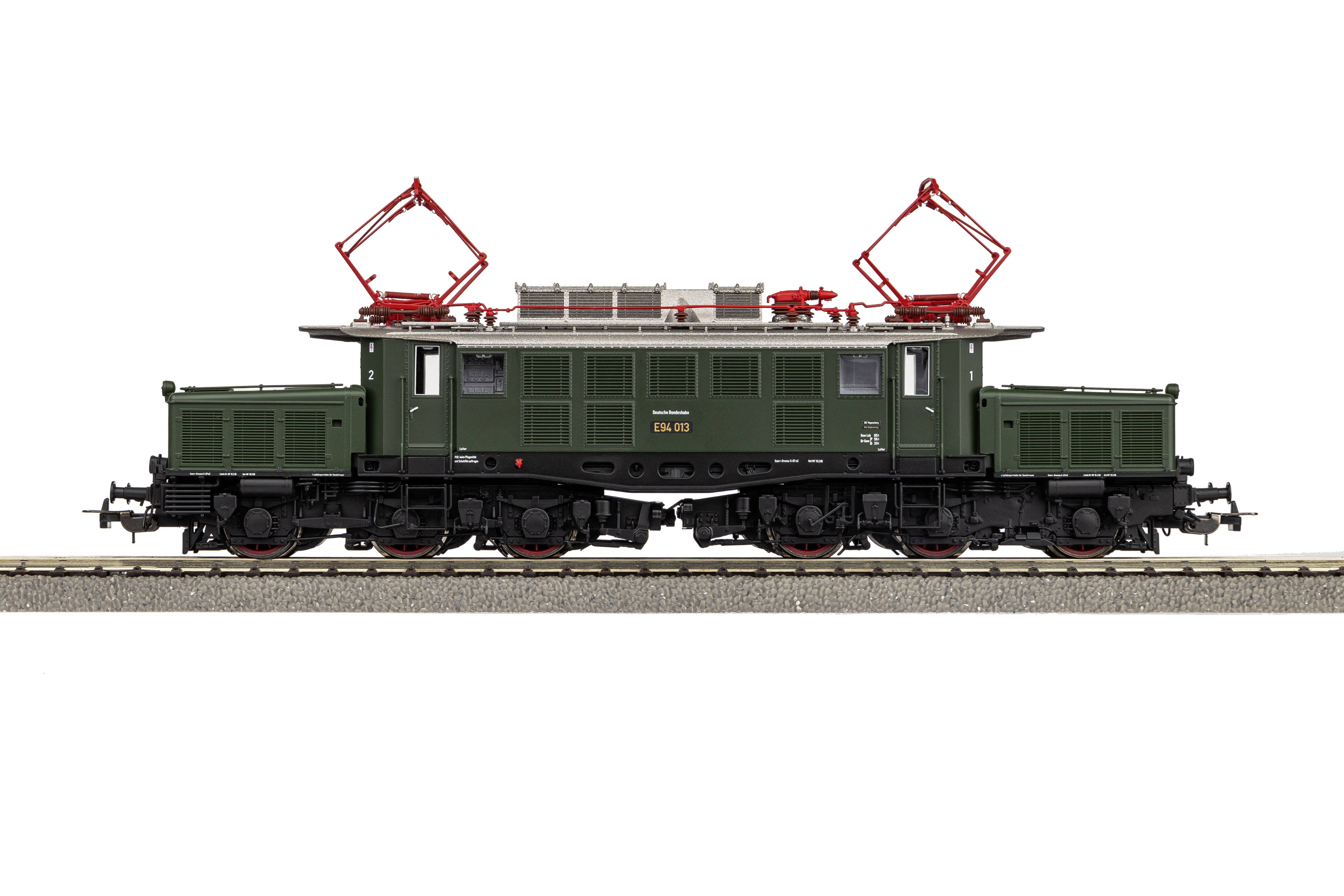 Elektrische Modelllokomotive in Olivgrün mit roten Stromabnehmern auf Gleis, Detailreich nachgebildet.