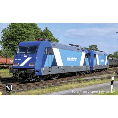 Zwei blaue, moderne Lokomotiven mit Aufschrift 'train charter' auf Eisenbahngleisen. Hintergrund zeigt Bäume und blauen Himmel.