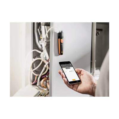 Eine Person verwendet ein Smartphone, um Daten von einem an einem Maschinenkabel befestigten Messgerät abzurufen.