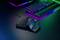 Gaming-Keyboard mit RGB-Beleuchtung und ein einhändiger Gaming-Controller auf einem Tisch, dunkler Hintergrund, Neonfarben.