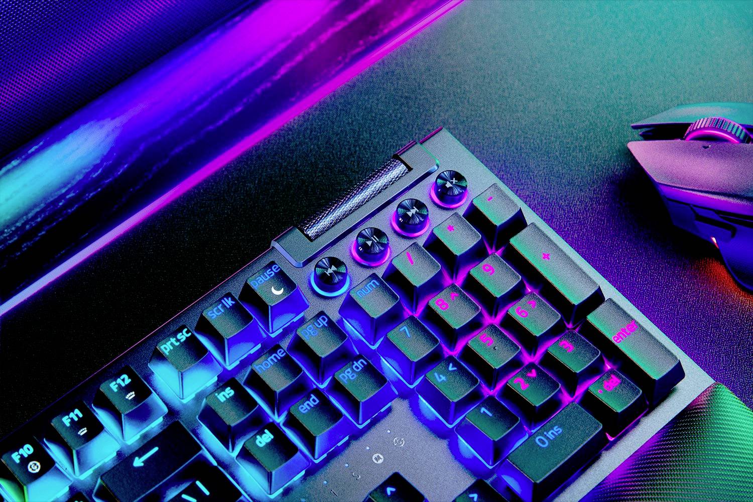 RGB-beleuchtete Gaming-Tastatur und Maus auf einem Schreibtisch; neonfarbene Beleuchtung erzeugt ein futuristisches Ambiente.