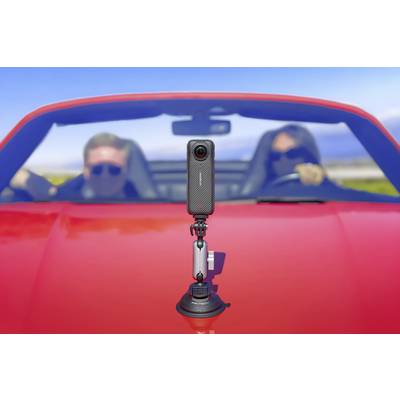 Eine Kamera ist auf ein rotes Cabrio montiert, in dem zwei Personen sitzen. Die Kamera ist im Fokus, während die Personen unscharf sind.