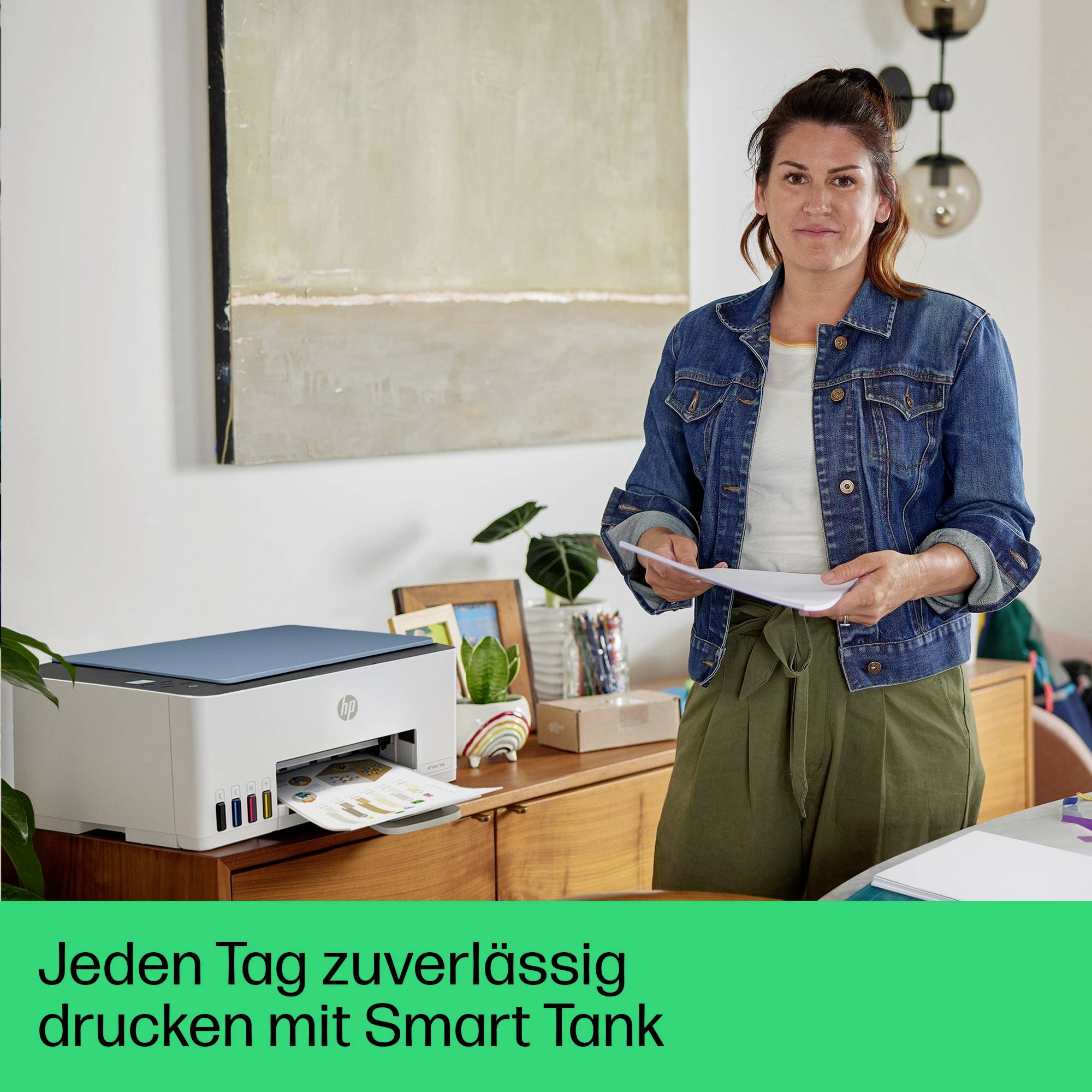 Eine Frau steht neben einem Drucker in einem modernen Büro. Text darunter: 'Jeden Tag zuverlässig drucken mit Smart Tank'.