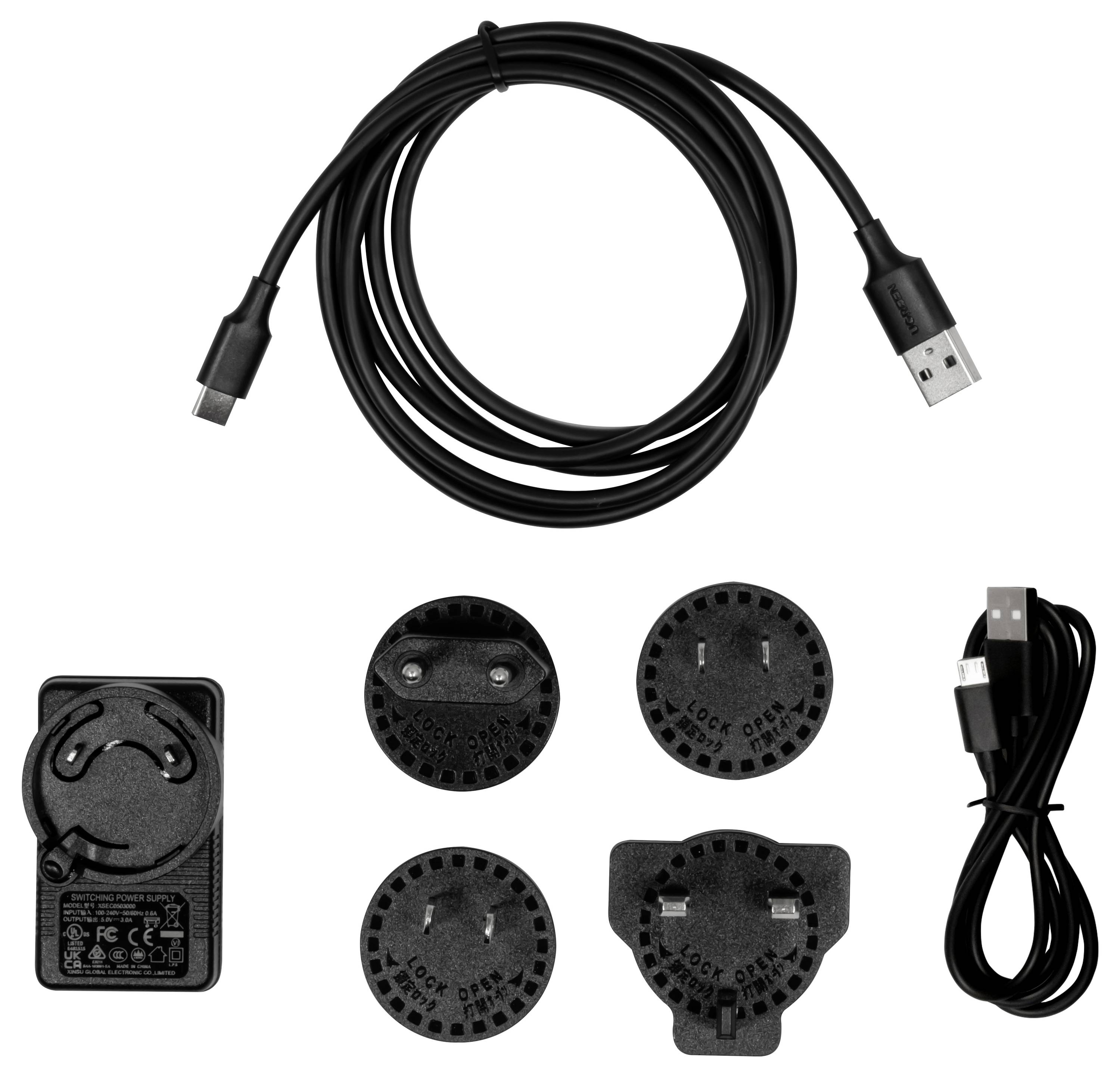Ein USB-C-Kabel, Netzteil und vier auswechselbare Steckeradapter für verschiedene internationale Steckdosentypen werden gezeigt.