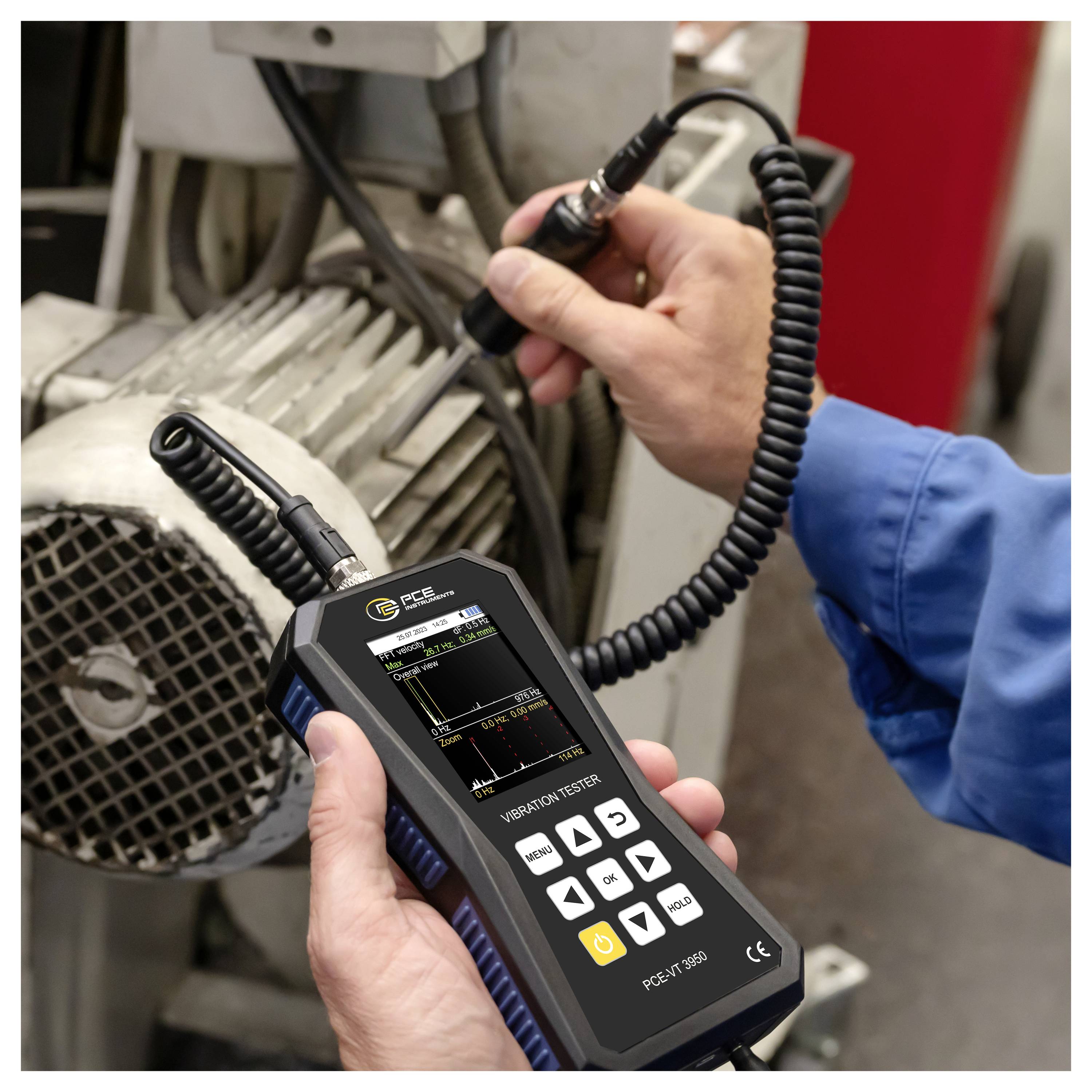 Person, die einen tragbaren Vibrationsprüfer an einem Industriemotor verwendet, um Maschinenvibrationen zu messen.