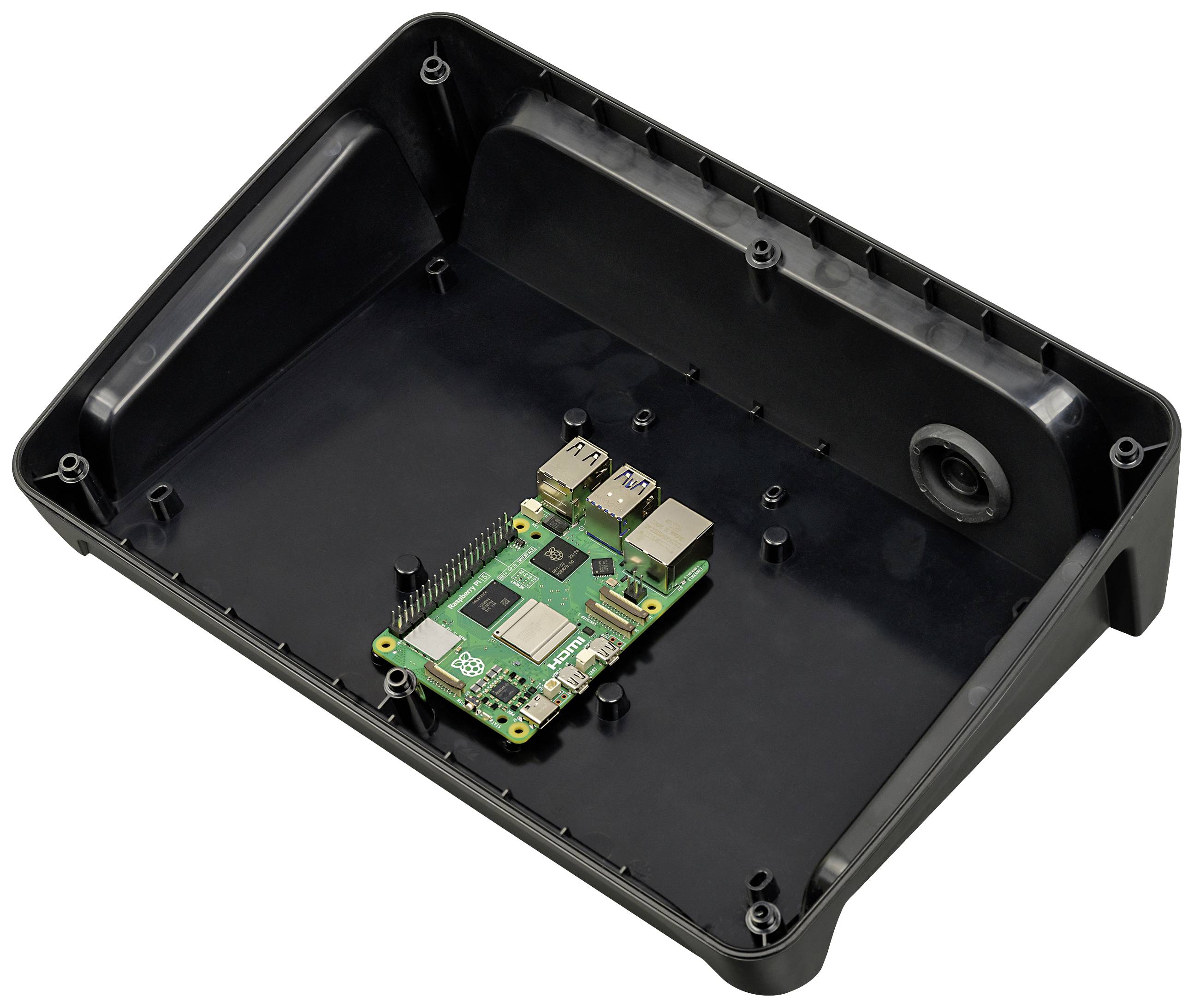 Ein kleiner grüner Computerchip in einem offenen schwarzen Gehäuse, das Platz für zusätzliche Hardware zu bieten scheint.