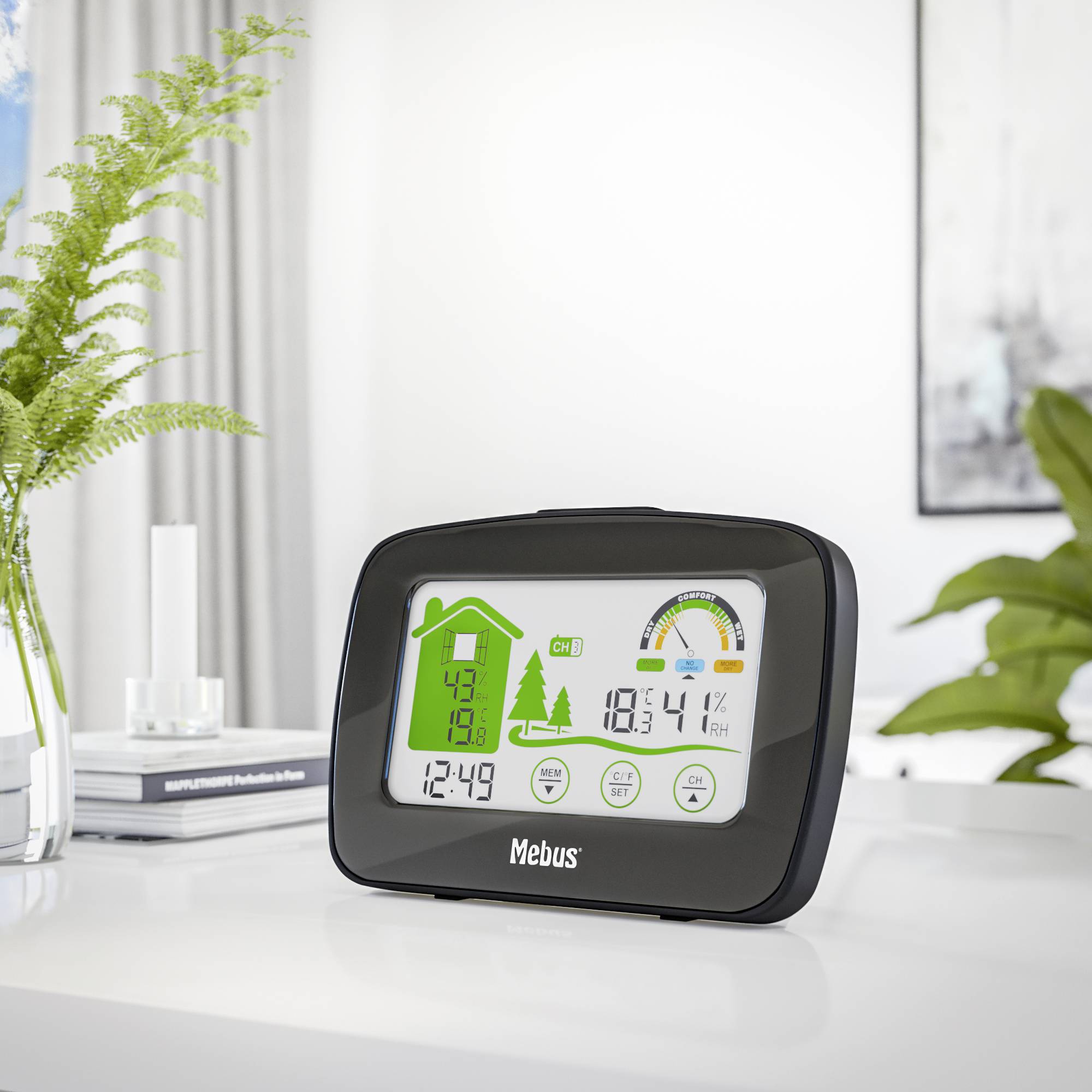 Eine digitale Wetterstation auf einem Tisch zeigt die Innentemperatur, Luftfeuchtigkeit, Uhrzeit und ein Symbol für sonniges Wetter an.