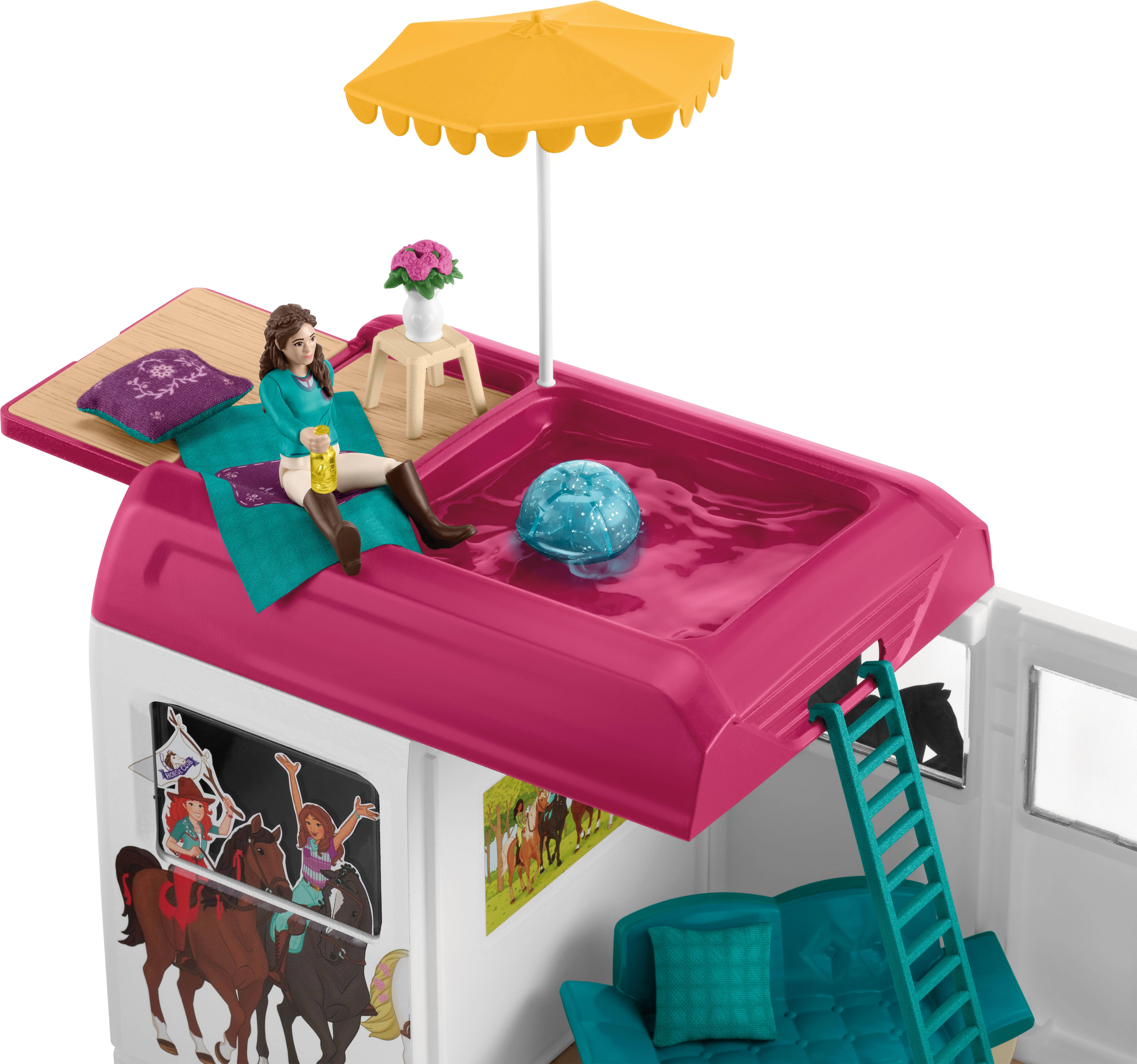 Frau entspannt auf kleinem Dachpool mit gelbem Sonnenschirm und Getränk. Darunter ein Raum mit blauer Couch und Poster an der Wand.