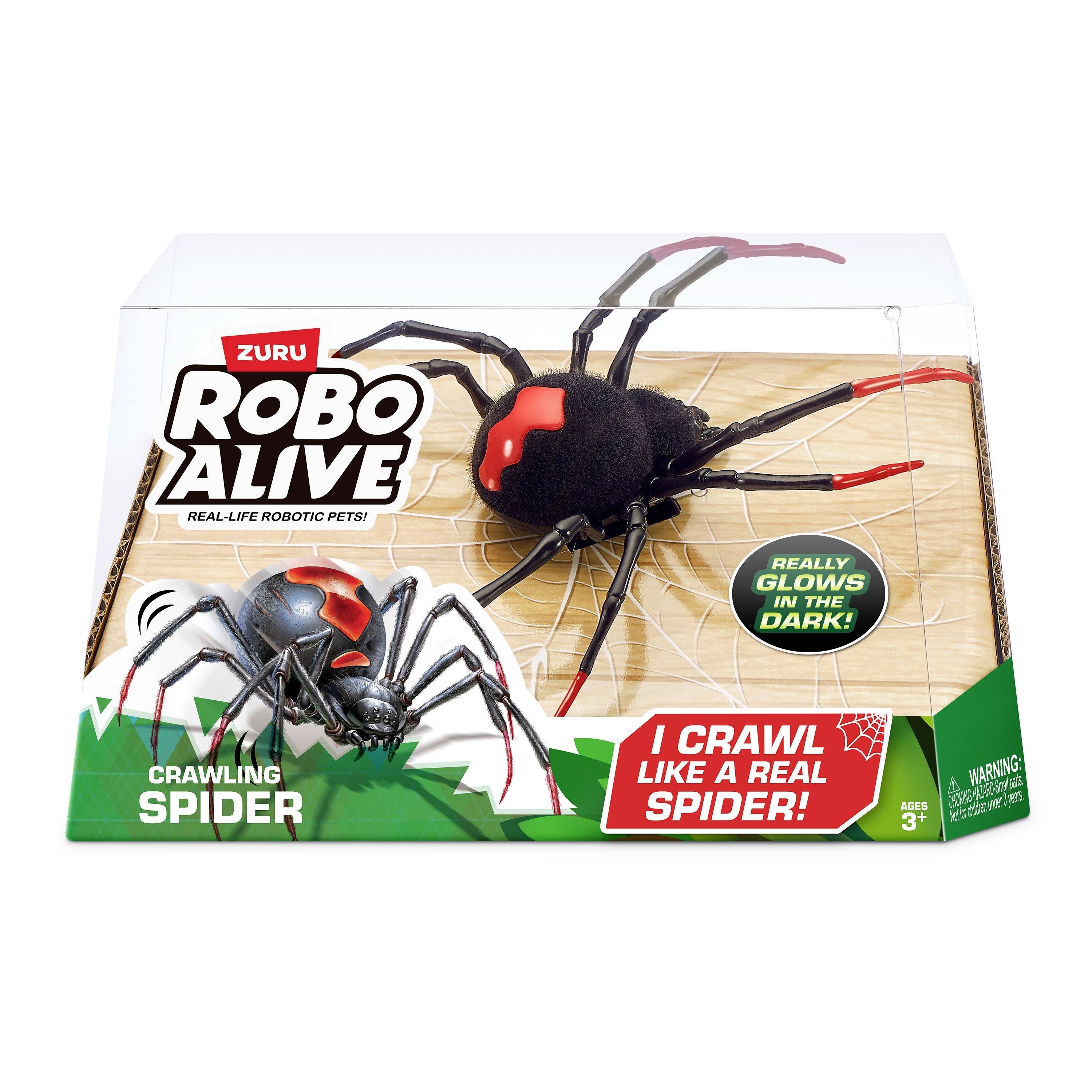 Spielzeugroboter-Spinne in der Verpackung. Text weist auf realistische Krabbelfähigkeiten und Leuchten im Dunkeln hin. Geeignet ab 3 Jahren.
