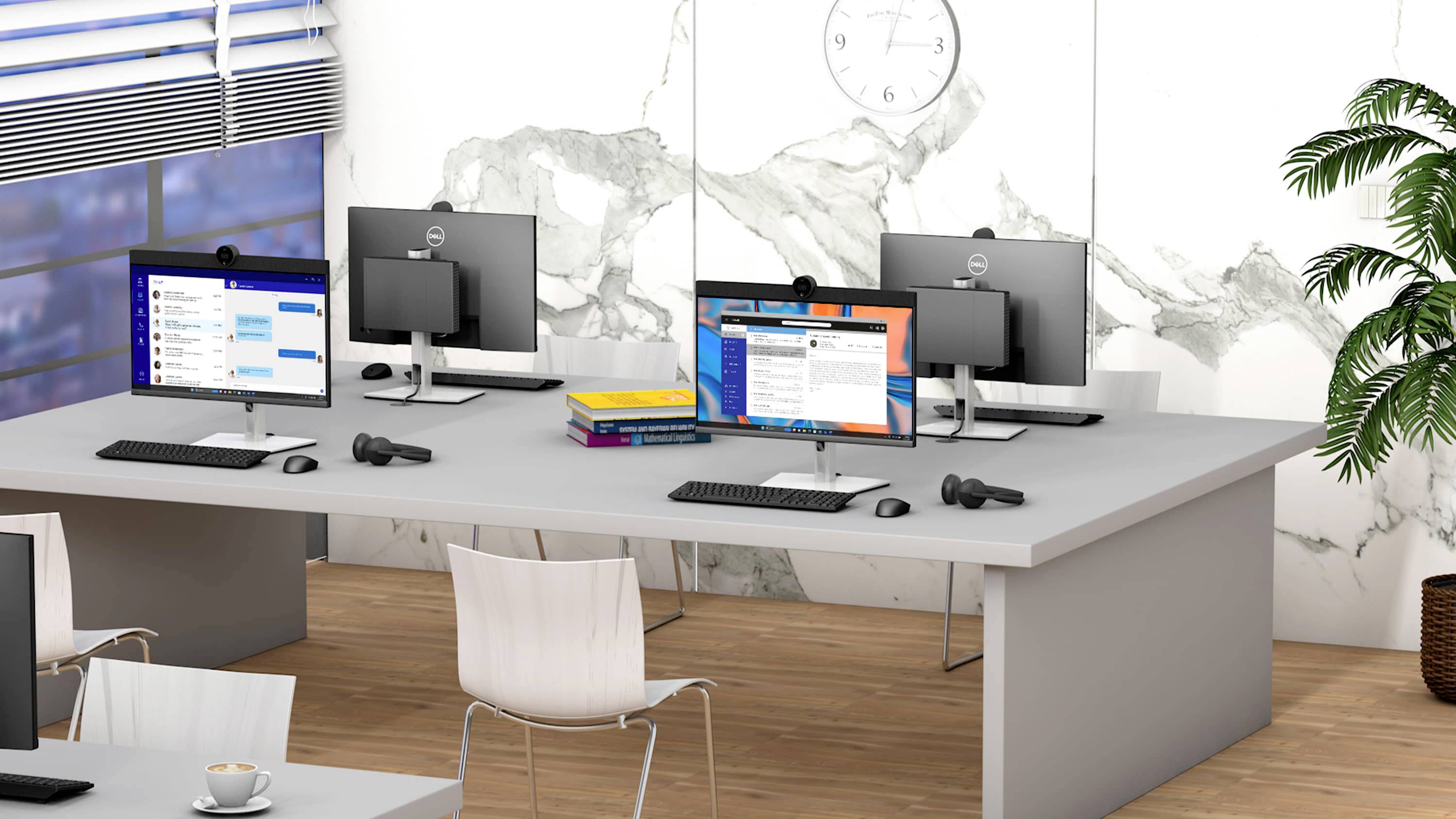 Zwei Schreibtische mit drei Monitoren, Tastaturen und Mäusen. Bücherstapel auf einem Tisch. Hintergrund mit Marmorwand und Uhr.