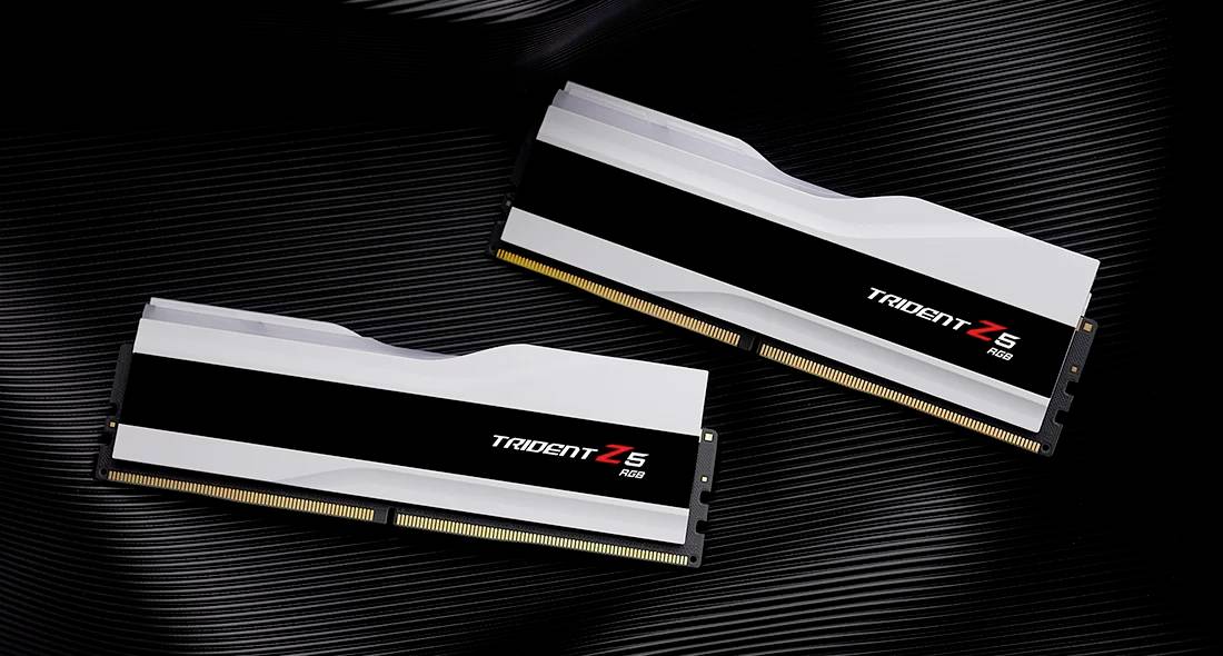 Zwei RAM-Module der Marke 'Trident Z5 RGB' liegen diagonal auf einer dunklen, strukturierten Oberfläche.