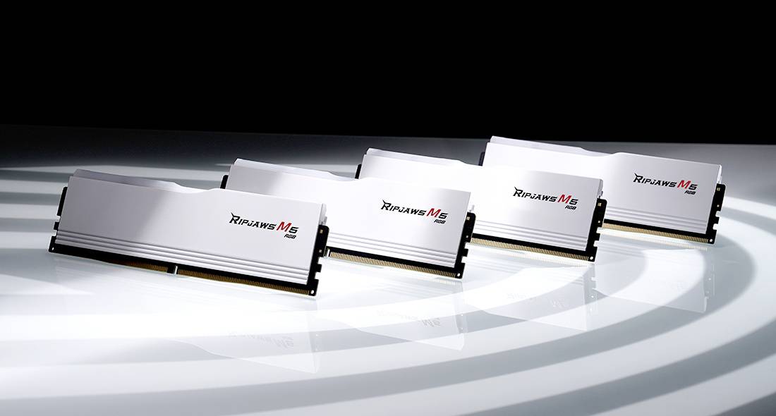 Vier Computer-RAM-Module der Marke Mach Xtreme liegen nebeneinander auf einem gestreiften, glänzenden Untergrund.