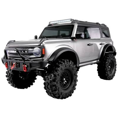 Geländewagen in Silber mit großer Bodenfreiheit und Offroad-Bereifung, seitliche Ansicht.