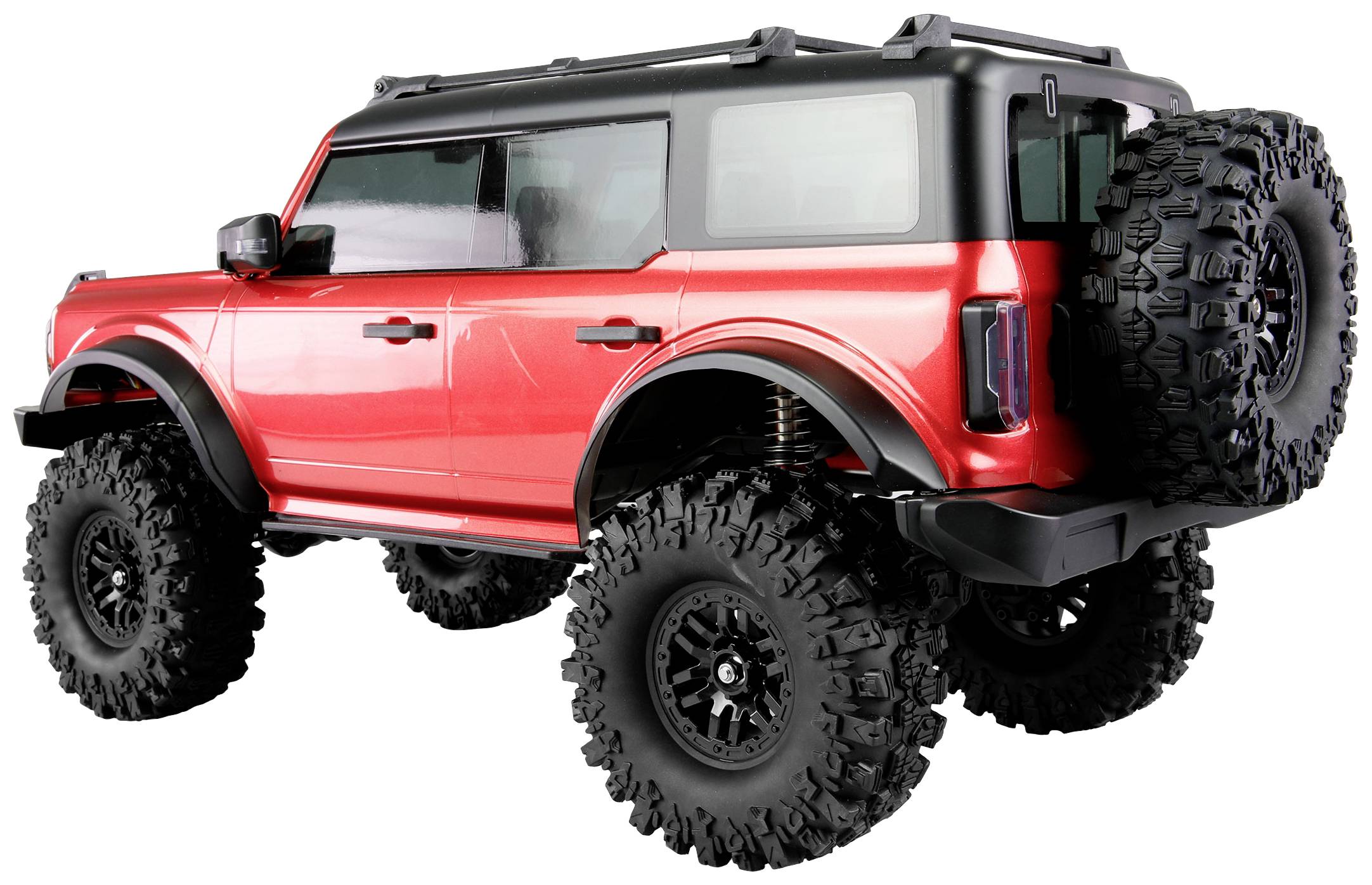 Ein rotes Geländewagenmodell mit großen Reifen, robustem Design und Reserverad am Heck.