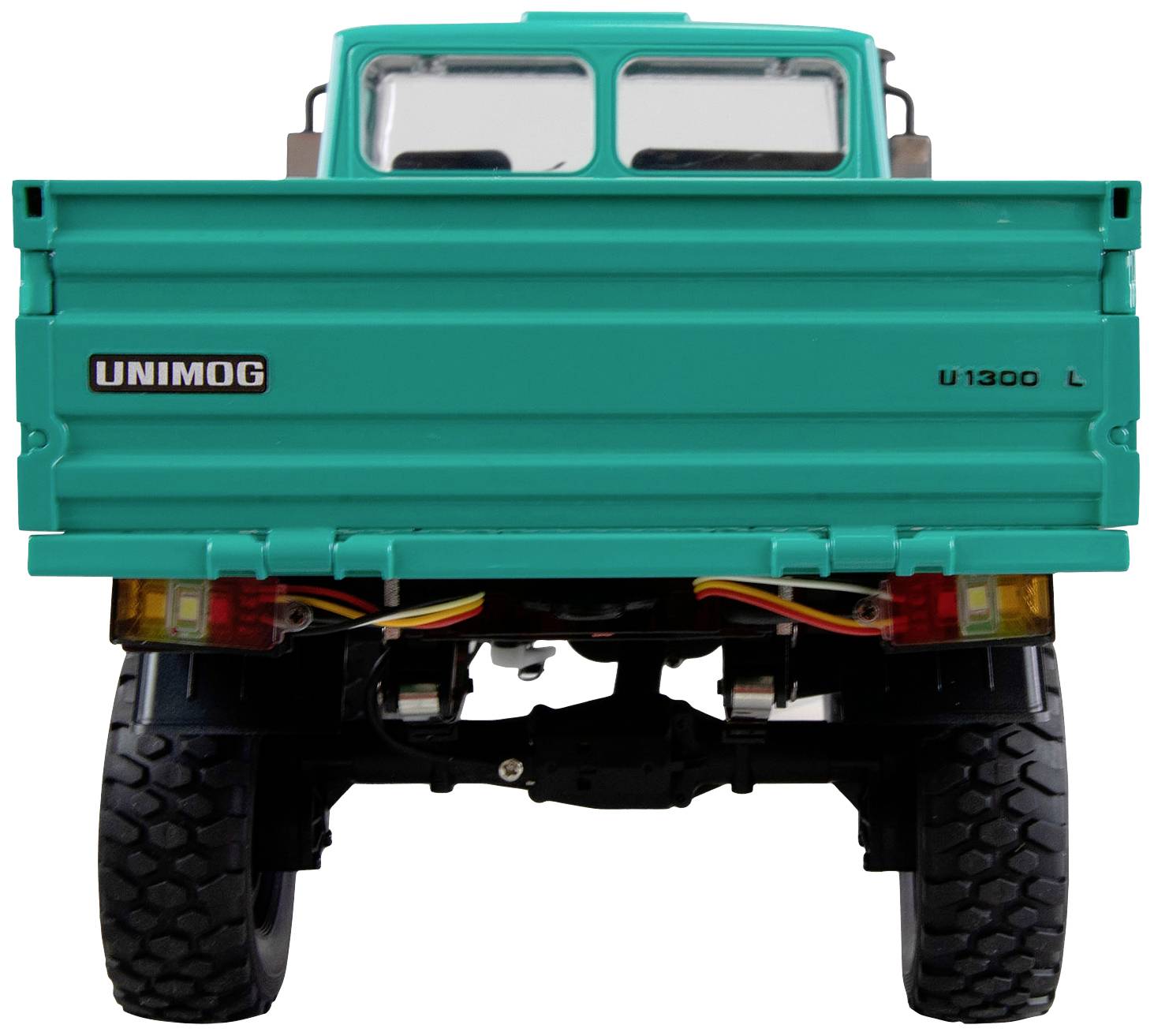 Rückansicht eines türkisfarbenen Unimog U1300 L mit robusten Reifen und sichtbarer Fahrgestellstruktur.
