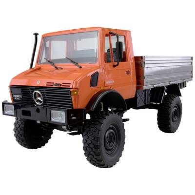 Ein orangefarbener Lkw mit robusten Reifen, geeignet für unwegsames Gelände, steht aufrecht. Mercedes-Logo auf der Front sichtbar.