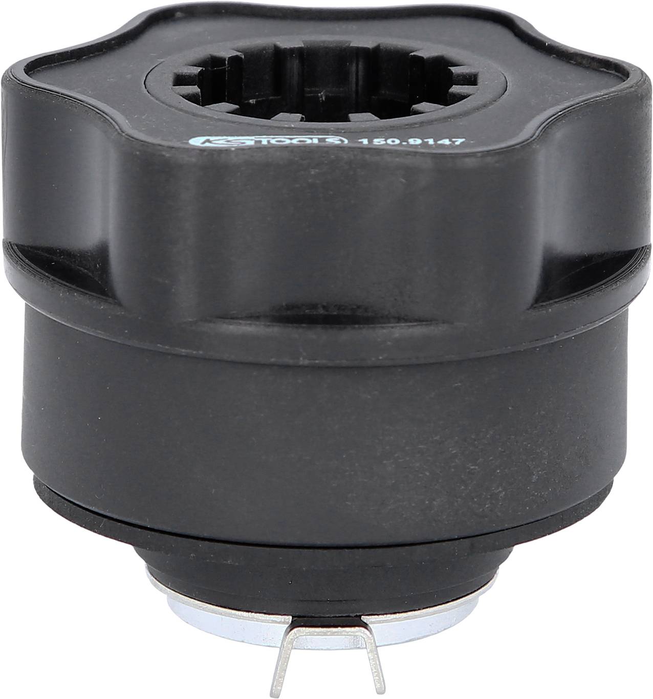 Schwarzes mechanisches Bauteil mit verzahntem Innenraum und Metallklemme unten. Möglicherweise ein Werkzeugaufsatz oder Adapter.