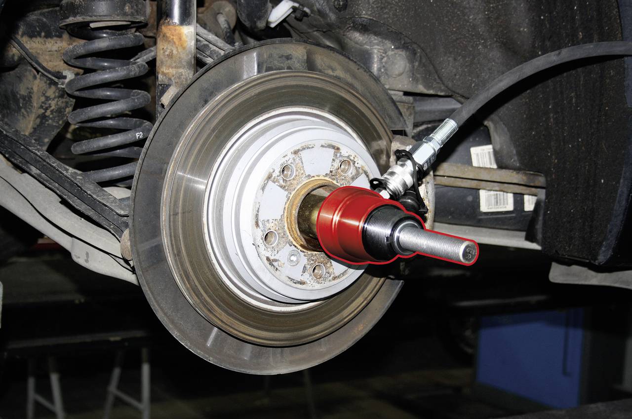 Ein Automechanikerwerkzeug ist an einer Bremsscheibe befestigt und wird für Reparaturarbeiten verwendet.