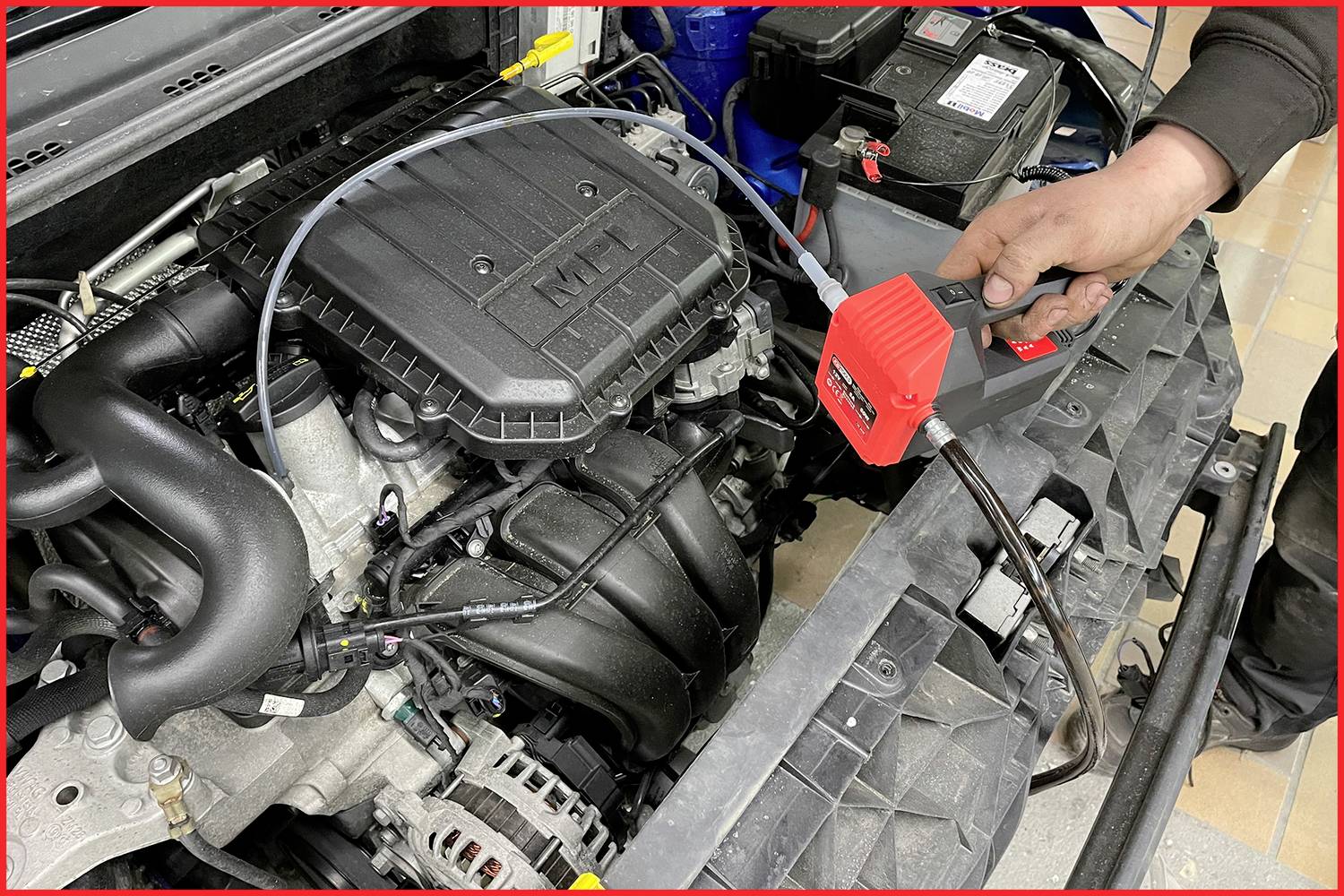 Eine Person lädt ein Fahrzeug, während sie sich in einem Gebäude befindet.