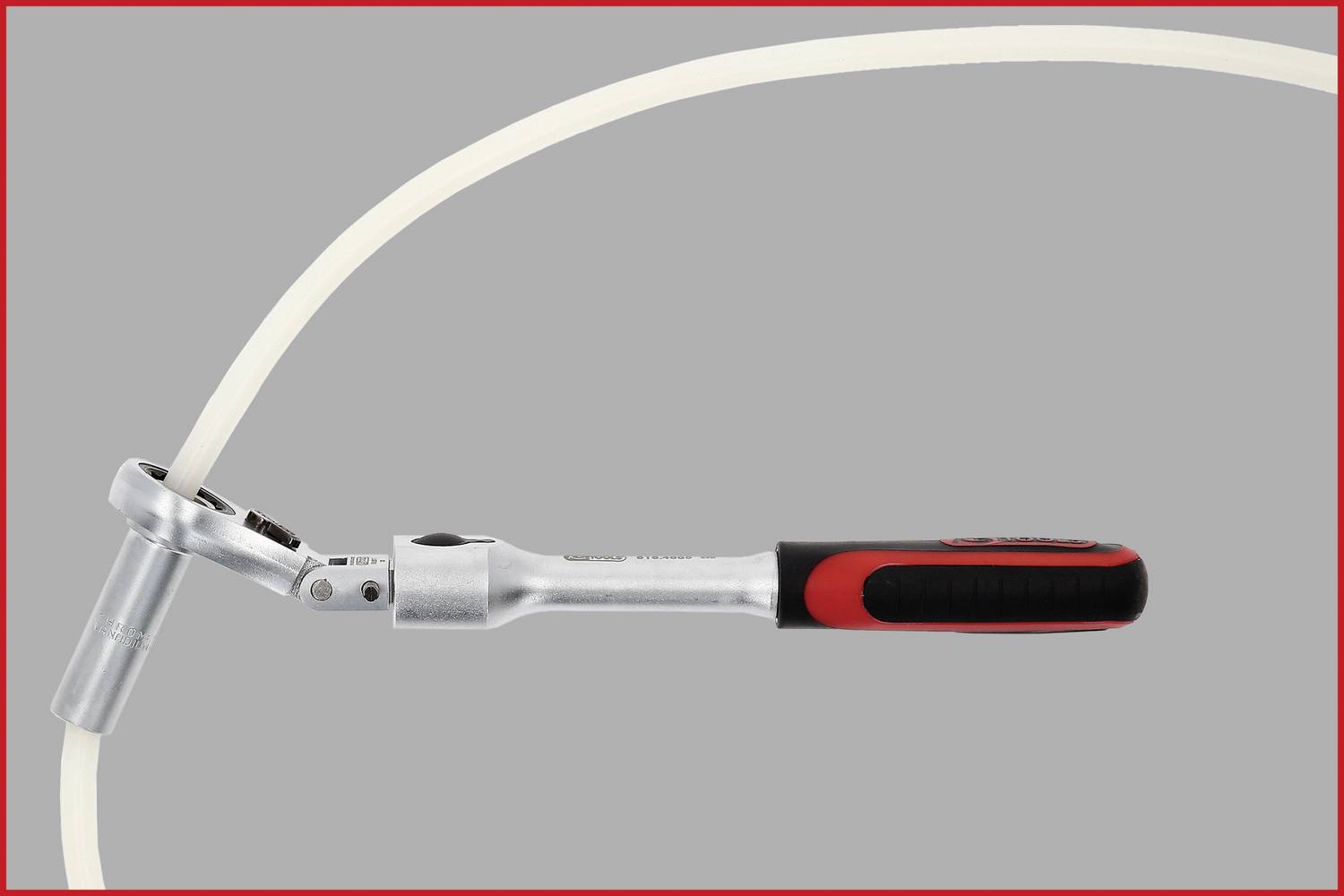 Eine silberne Ratsche mit schwarzem Griff bewegt sich entlang eines gebogenen weißen Kabels auf grauem Hintergrund.