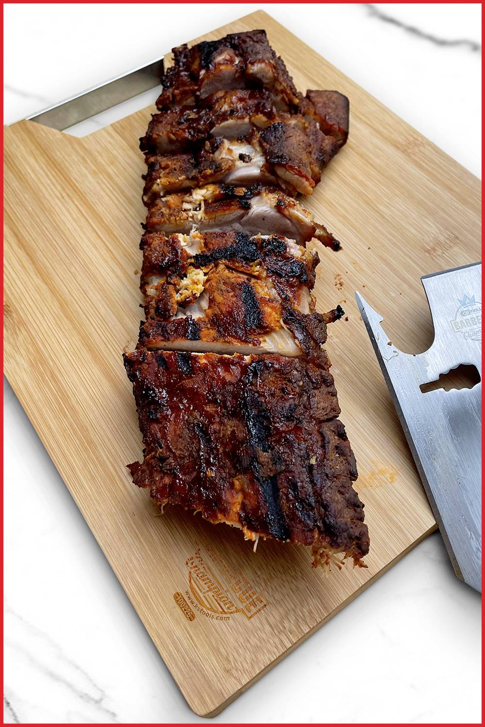 Gegrillte Rippchen auf einem Holzbrett mit Grillmesser; saftig, knusprig und appetitlich angerichtet.
