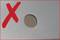 Rotes 'X' neben einem Loch in einer grauen Oberfläche, möglicherweise um anzuzeigen, dass das Loch unerwünscht oder fehlerhaft ist.