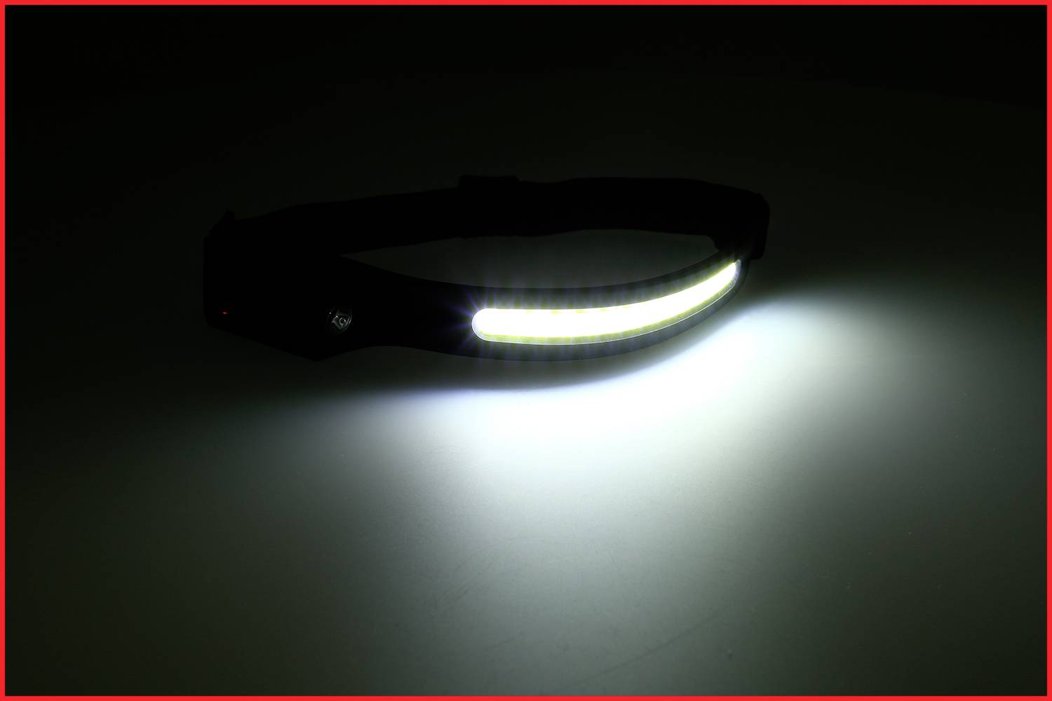Ein leuchtendes Stirnband zeigt eine helle LED-Lichtleiste. Es scheint auf ein dunkles Umfeld und hebt sich durch starken Kontrast ab.